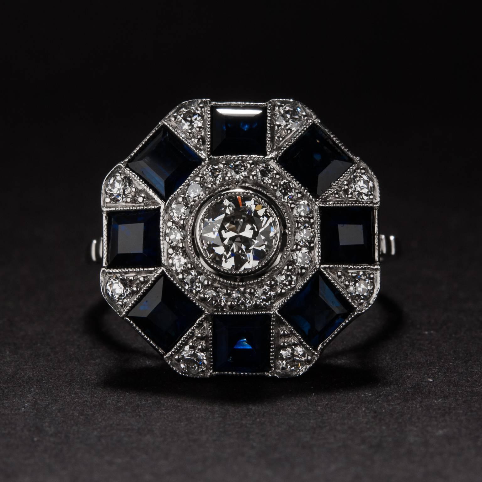 The lovely ring has a .38 carat center diamond and 8 sapphires for a total of 2.40 carats. The beautiful platinum mounting features an additional .40 total carats of diamond. 

This ring is currently size 7.