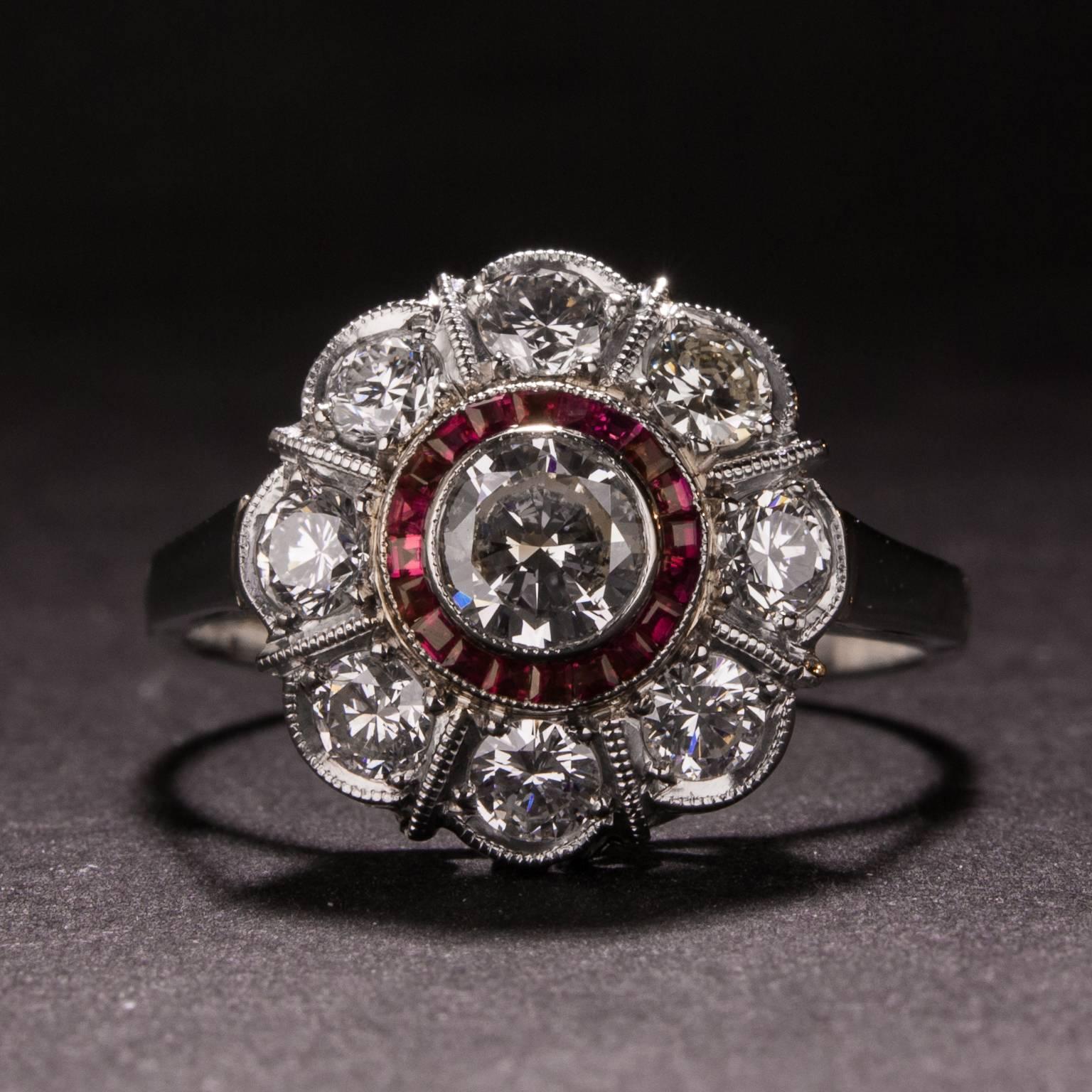 A beautiful diamond and ruby ring set in an elegant platinum mounting. The center diamond weighs .42 carats and it is surrounded by 8 accent diamonds for an approximate combined weigh of 1.00 carat. The center diamond is also surrounded by a halo of