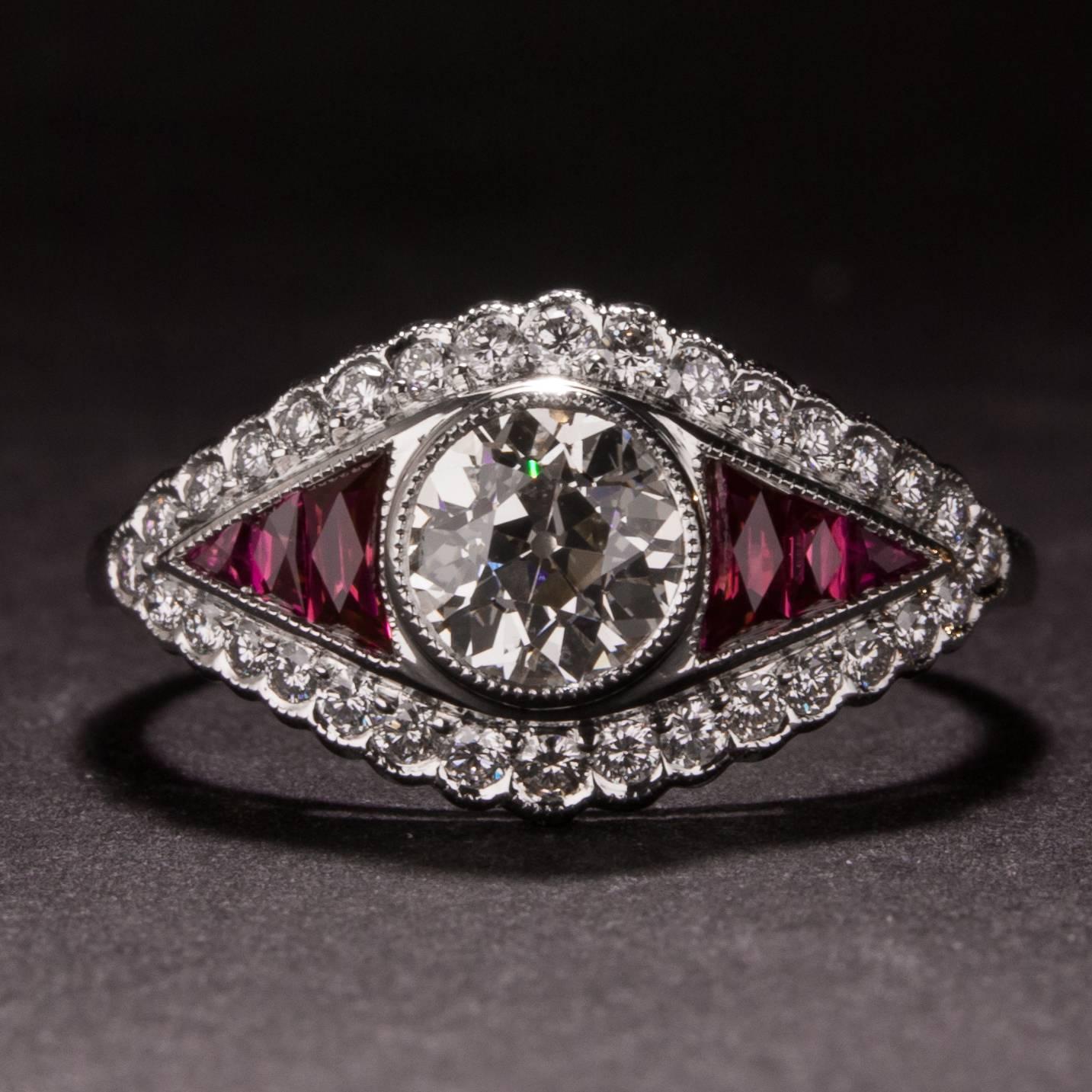 This lovely ring features a .76 carat old mine cut center diamond (Estimated J color, VS1 clarity) and 6 rubies weighing a total of 1.25 carats. The mounting is crafted in platinum and has an additional .31 total carats of accent diamonds. 

This
