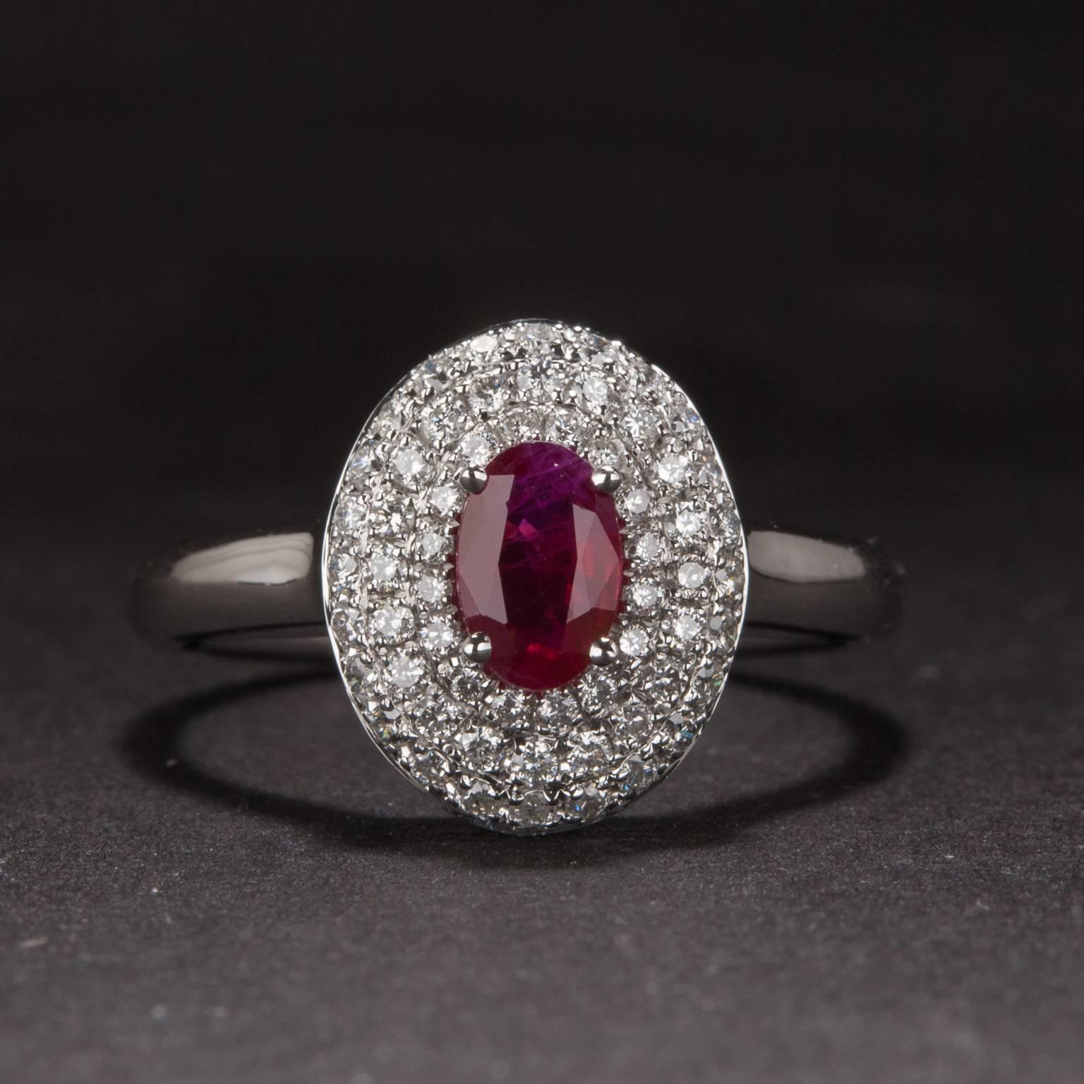 This beautiful ring features a .49 carat center ruby that is accented by a halo of three rows of diamond weighing a combined total of .36 carats. This piece is .crafted in 14k white gold and is currently size 7.