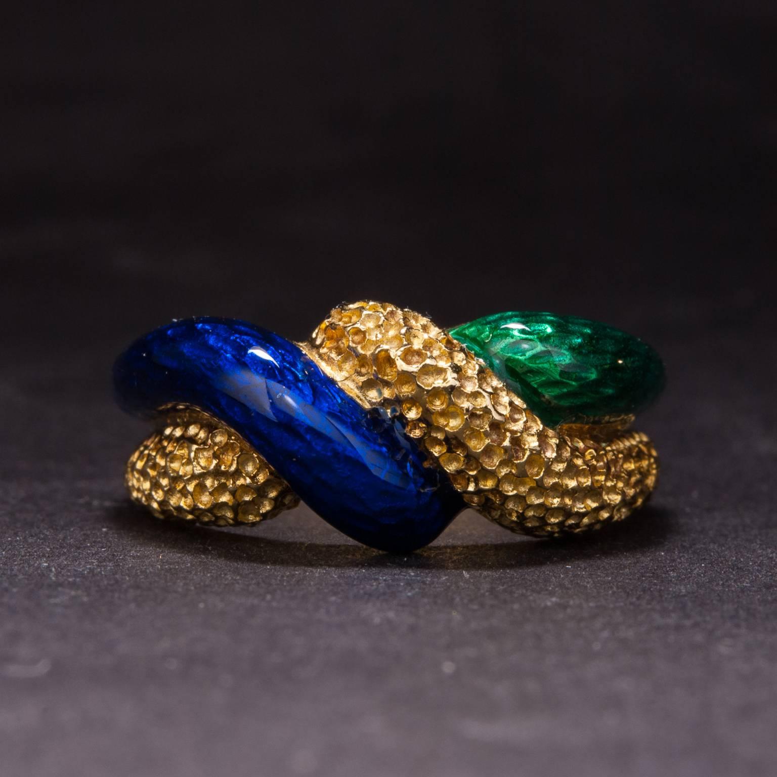 This lovely ring was hand-crafted circa 1960 and features beautiful blue and green enamel work along an 18k yellow gold mounting. This ring is currently size 7.5.
