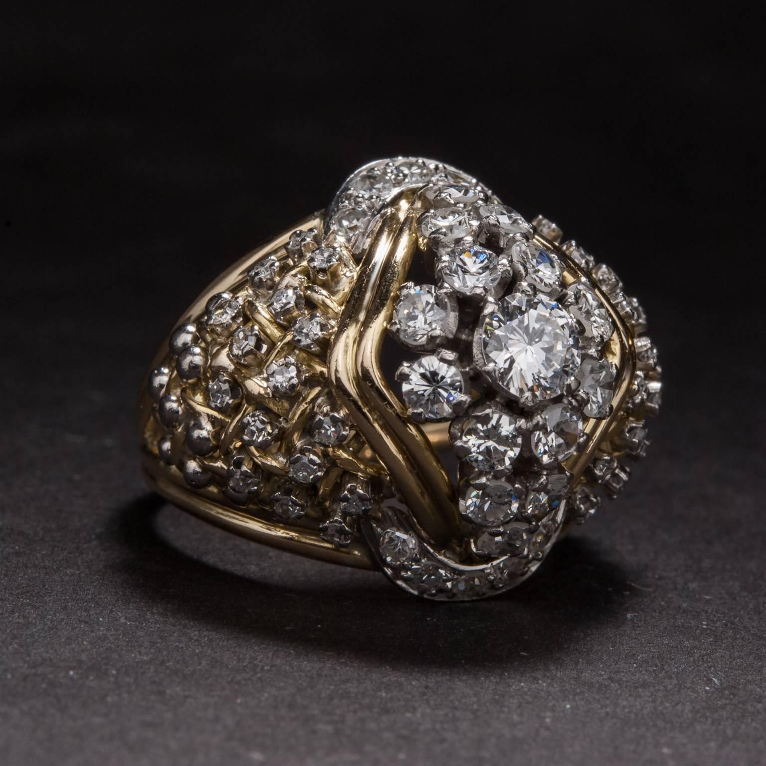 This extraordinary cluster diamond was hand-crafted circa 1940 in 18 karat white and yellow gold. The center diamond weighs .38 carats and it is surrounded by 1.75 total carats of accent diamonds. The head of the ring measures 19.75mm tall by 23mm