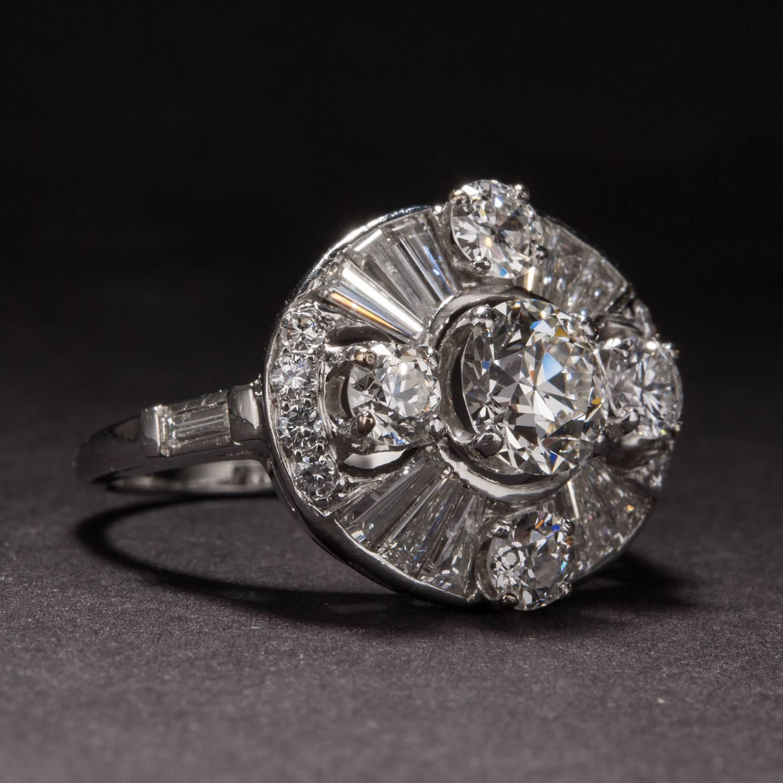 This stunning retro ring features a 1.35 carat center diamond, 1.50 total carats of side diamonds, and 1.30 total carats of accent baguette diamonds. This piece was crafted in platinum circa 1940 and is currently sized at 9, although it may be sized