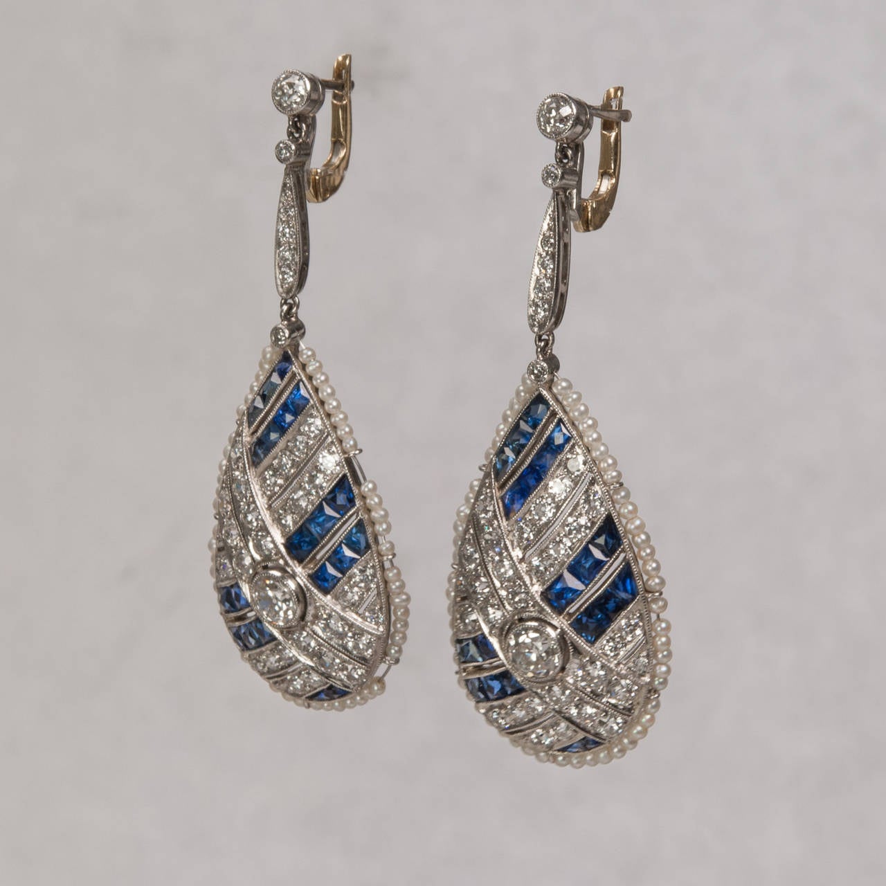 A dazzling set of diamond and sapphire dangle earrings .The center Old European cut diamonds weigh approximately .50 carats each and the remaining accent diamonds total approximately 2.00 carats. Each earring is accented by vibrant custom cut french