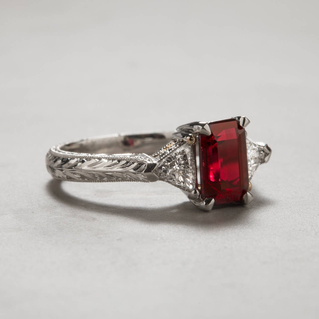 A beautiful ruby ring featuring intense true red color without a hint of pink. Delicate hand-engraved detailing covers the ring’s platinum shank. The 1.84 carat center ruby is accented by two diamonds weighing a total of .41 carats.
