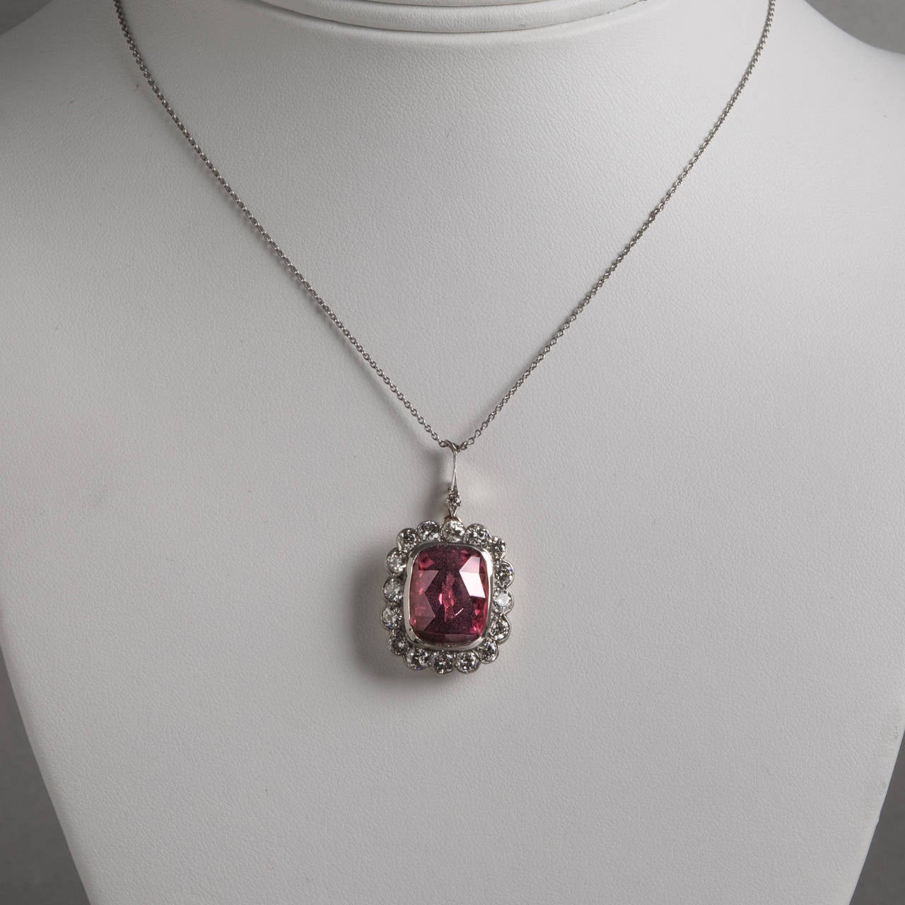 A gorgeous 8.61 carat rubelite tourmaline and diamond pendant. The vibrant red-pink tourmaline gemstone is surrounded by 1.60 carats of sparkling diamonds and set in two-tone 14 karat gold. The pendant rests on a 17″ chain.