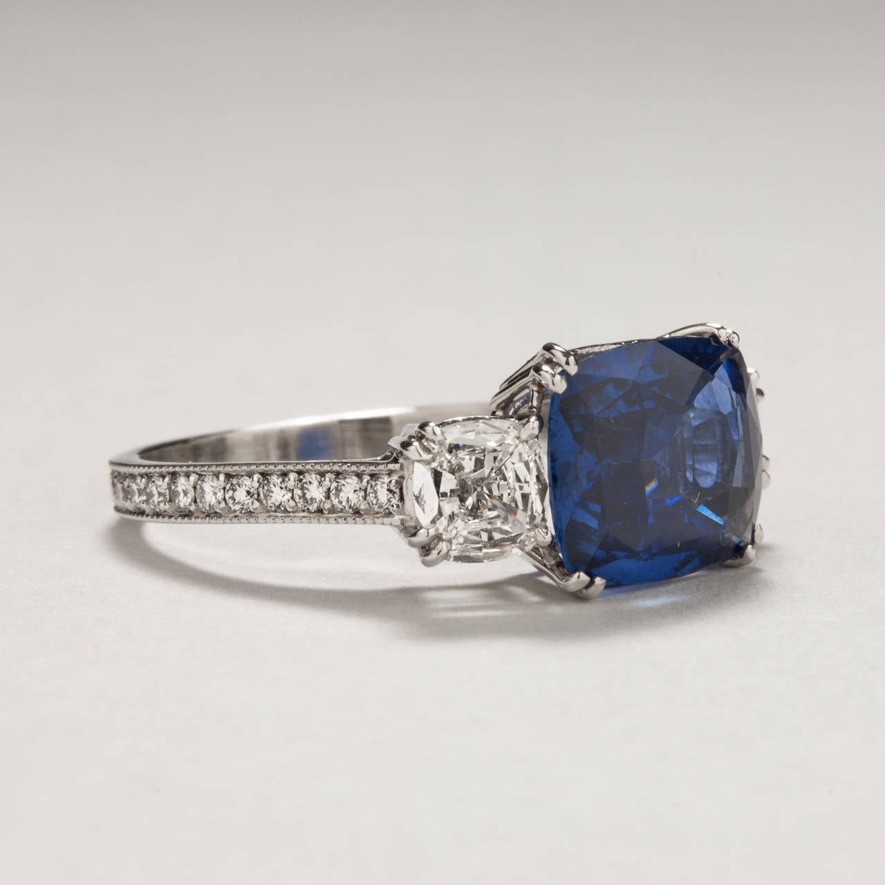 Simple and sophisticated, this platinum estate ring focuses attention on the highly desirable medium blue sapphire at its center which weighs 3.12 carats. Two lovely custom cut diamonds, totaling .60 carats, accentuate the sapphire on either side