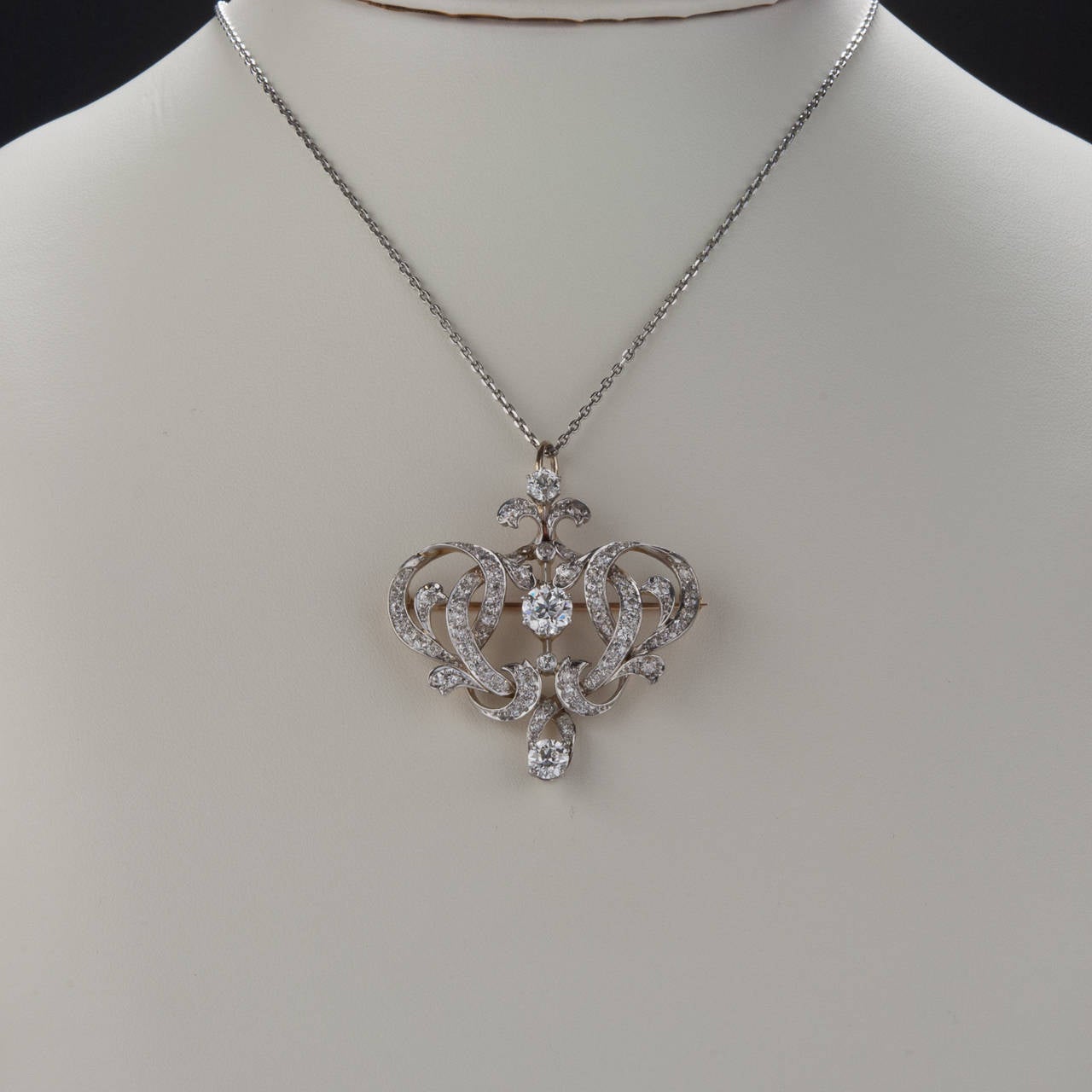 This is a gorgeous diamond pin/pendant from the Edwardian period of jewelry design. This piece is made with platinum on gold and stunning Old European cut diamonds. The diamonds have a combined weight of approximately 3.50 carats. This piece