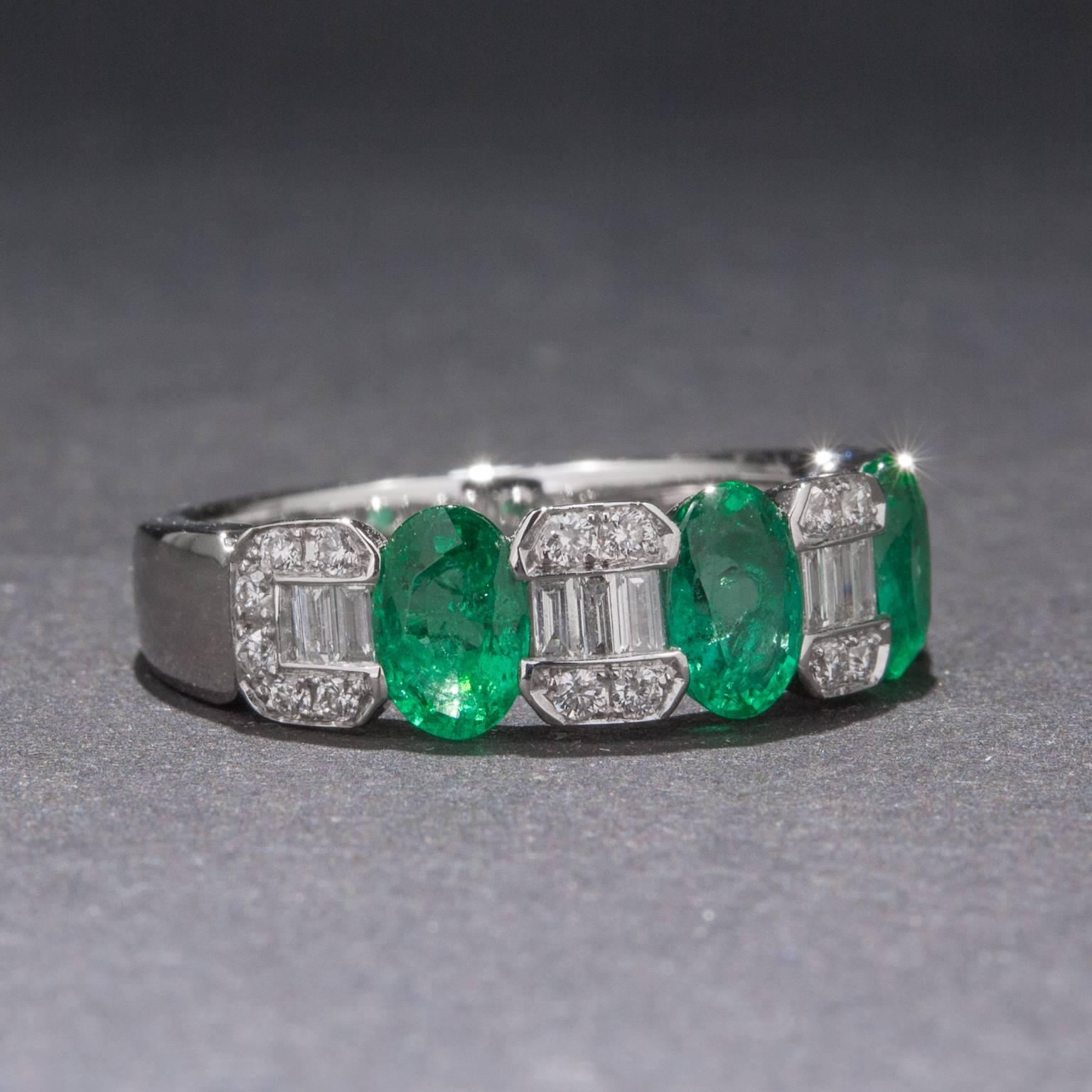 A stunning emerald and diamond band featuring 3 emeralds weighing a total of 1.24 carats. The ring also includes 10 baguette diamonds for a total of .18 carats and 20 round diamonds for an additional .18 carats. This lovely ring is made in 18k white