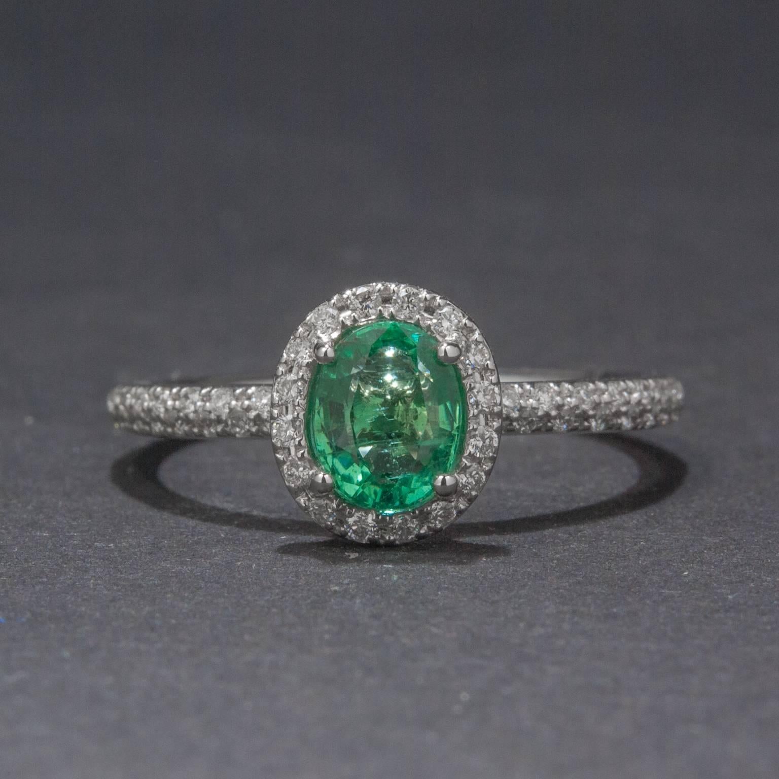 A supremely elegant ring with a .66 carat emerald at the center. The center emerald is haloed by 48 accent diamonds weighing a total of .20 carats. This beautiful piece is made in 18k white gold.