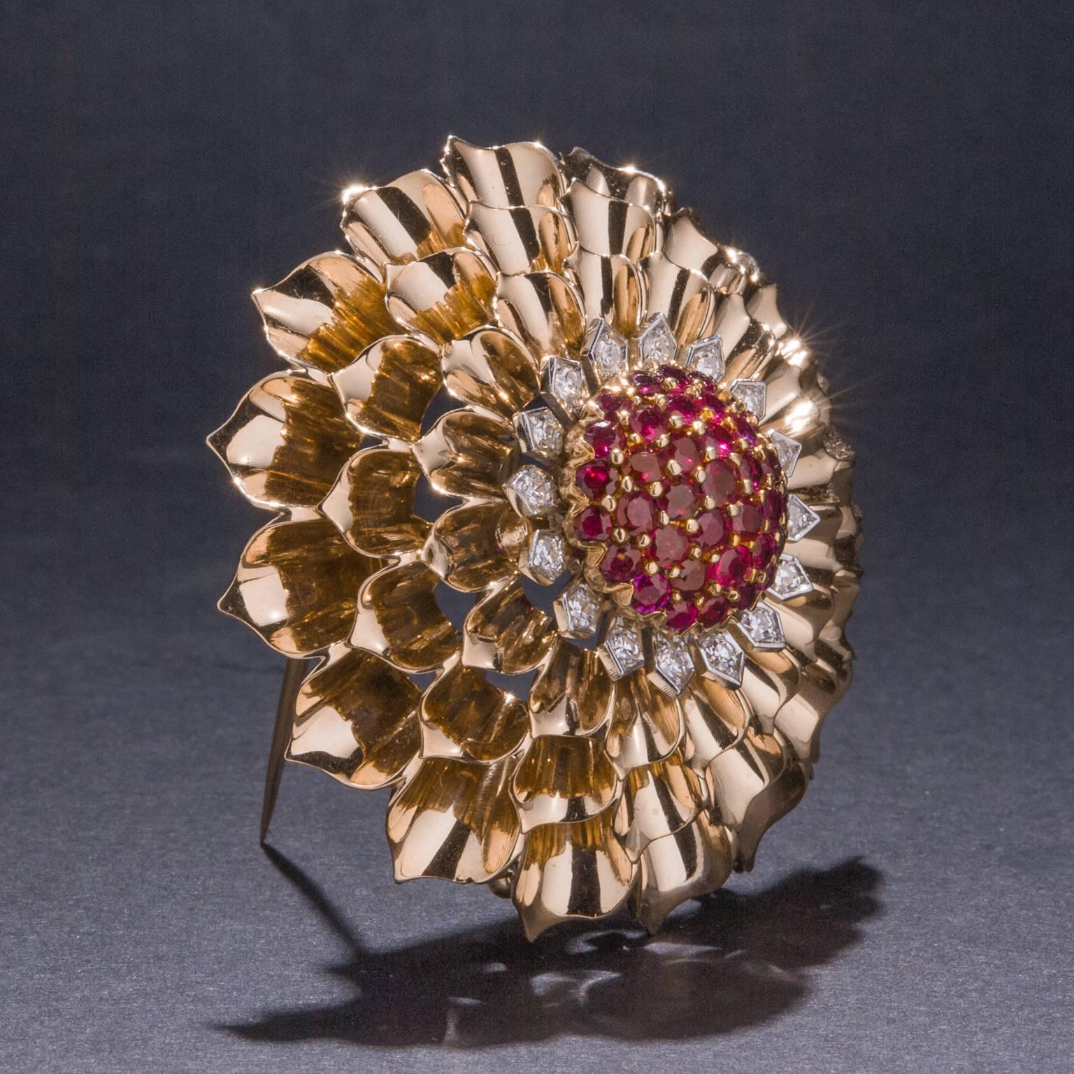 This stunning vintage Tiffany & Co. brooch features 37 rubies for a total weight of 1.40 carats and 16 diamonds weighing a total of .48 carats. This brooch takes the form of a flower with the petals are crafted in gleaming yellow gold. The piece