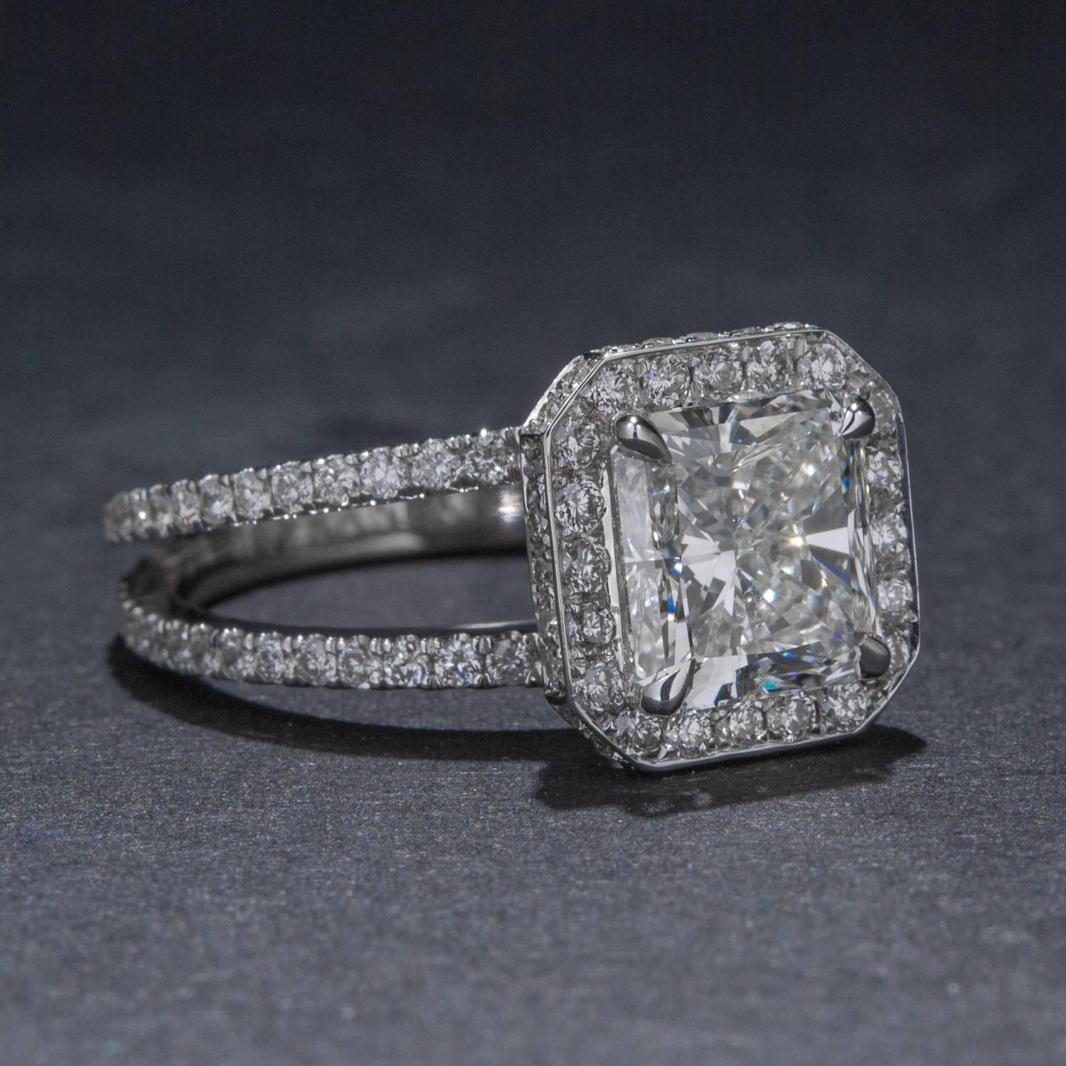 This gorgeous piece features a 2.05 carat Radiant Cut center diamond (F color, VS2 clarity) and .90 total carats of pave diamonds set in a halo around the center stone and along the split shank. This ring is made in 18k white gold and is size 6.75.