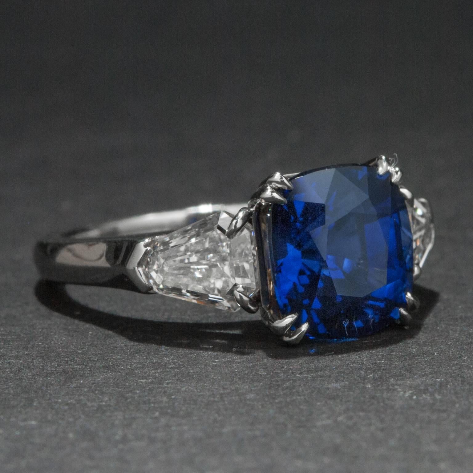 A lovely sapphire ring with tantalizing medium blue color. The cushion cut sapphire that sits at the ring's center weighs 4.19 carats and it is flanked by two beautiful diamonds weighing a total of 1.20 carats. The ring is crafted in platinum and is