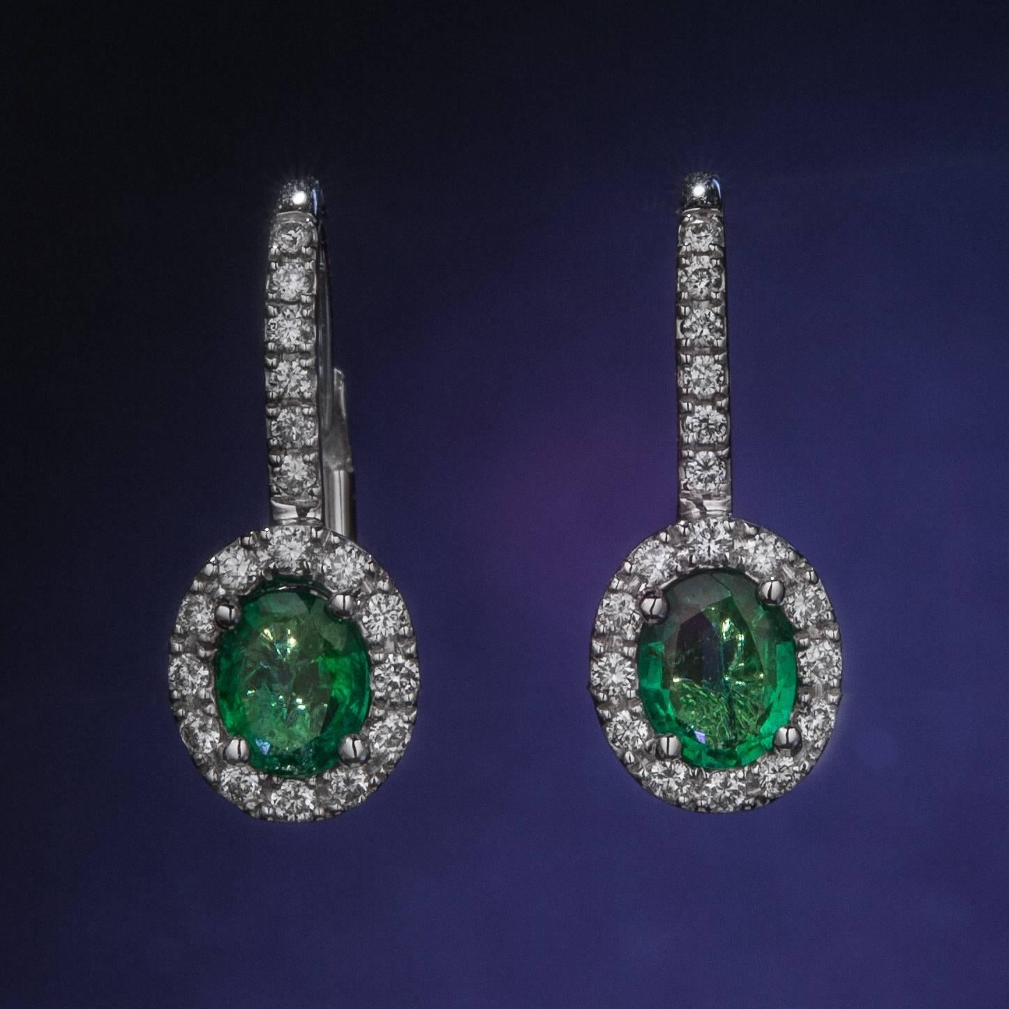 These lovely drop earrings are crafted in 18k white gold and display .50 carats of vibrant emerald gemstones.  The rich green color is accented by .20 carats of brilliant pave diamonds.  This is a classic pair of emerald drop earrings!
