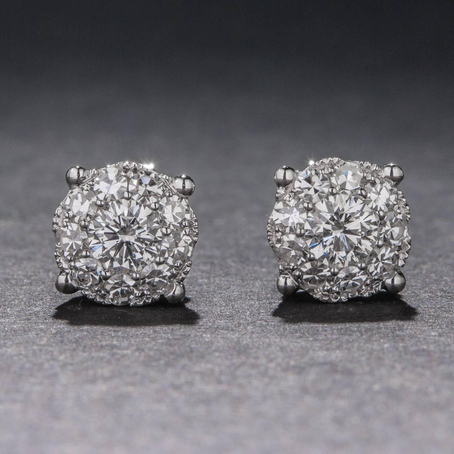 A bright and brilliant pair of diamond cluster earrings, each featuring a larger central diamond weighing approximately .20 carats each. The 18 surrounding diamonds have a total weight of .45 carats for a combined diamond weight of .85 total carats.