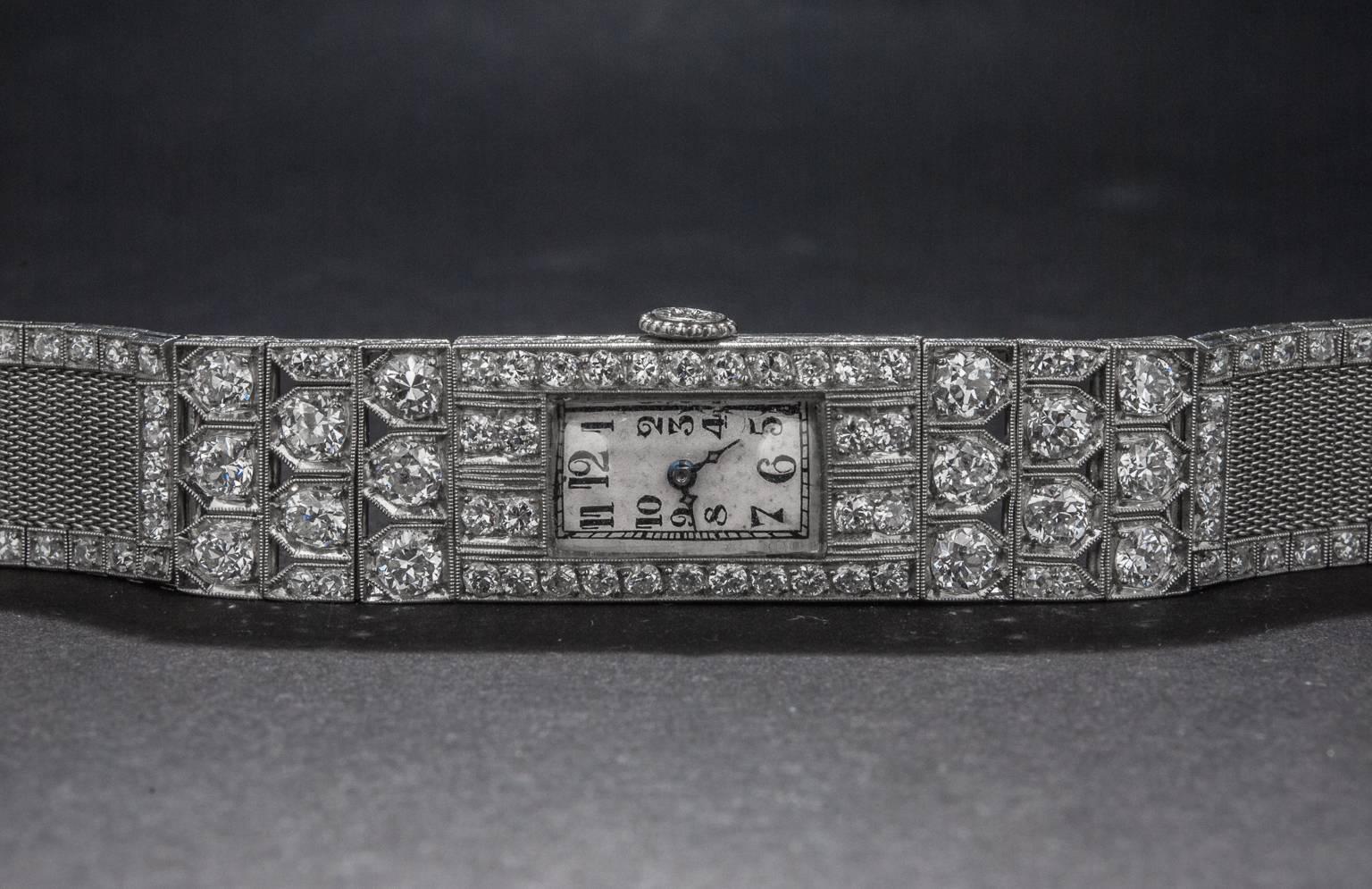 This extraordinary custom made Art Deco era case houses a manual-wind Audemars Piguet movement. The case features 146 diamonds weighing a total of 5.5 carats and is made in platinum. The bracelet is composed of a flexible platinum mesh and the piece