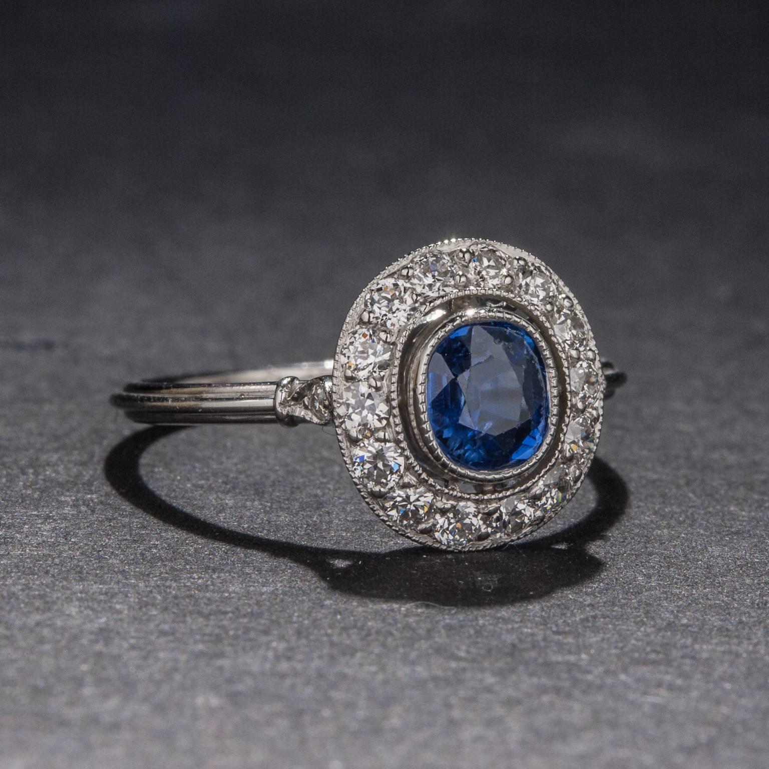 A lovely .50 carat sapphire sits at the center of this vintage style platinum ring. The center sapphire is surrounded by a total of .25 carats of diamond and the ring is currently size 6.25.