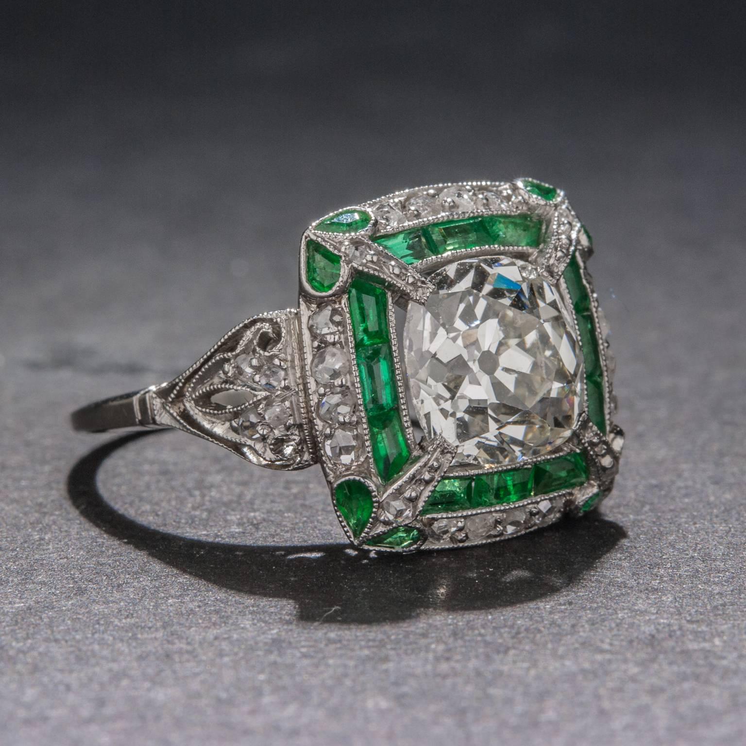 A beautiful Art Deco era ring with a 2.50 carat Old European Cut diamond at its center. The center diamond is complemented by .85 total carats of emerald and an additional .50 total carats of diamond. The ring is crafted in platinum and features