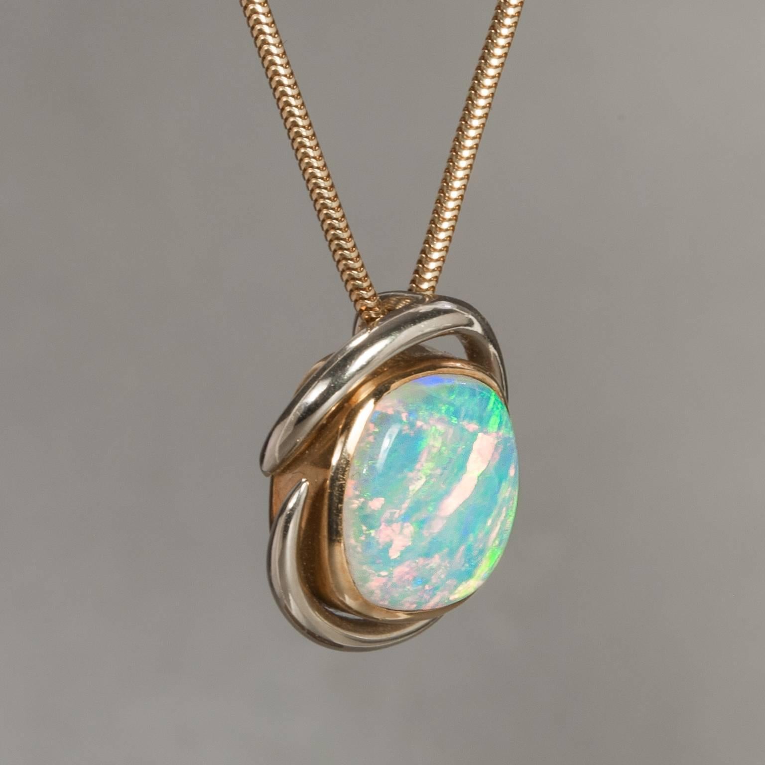 An elegant and curvaceous 5.00 carat Fire Opal pendant set in 18k white and yellow gold. This beautiful piece was crafted circa 1970 and comes on a short 15 inch snake chain in yellow gold.