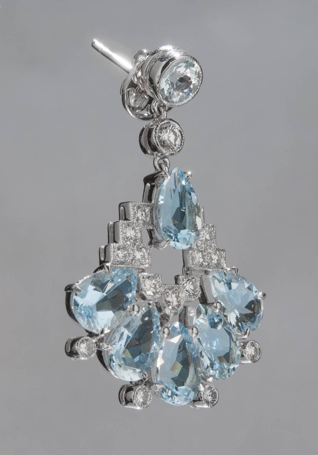 A lovely pair of chandelier earrings featuring bright diamonds and mesmerizing aquamarine gemstones. This piece is constructed in 18k white gold and includes 13.21 total carats of aquamarine and 1.49 total carats of diamonds. Laid flat, the earrings