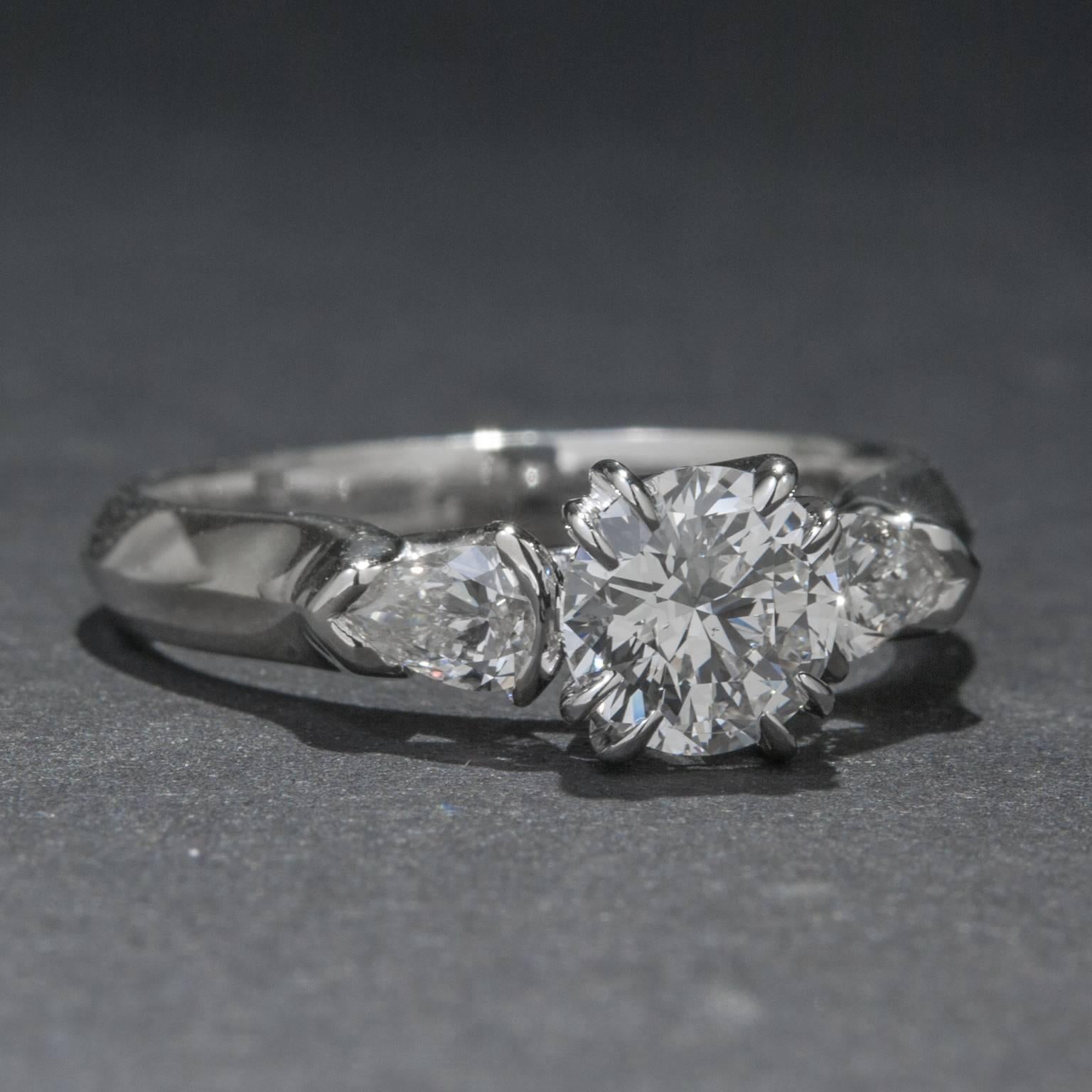 A beautiful three stone diamond ring with a classic look. This piece features a .90 carat GIA certified center diamond (F color, SI1 clarity) which is flanked by 2 pear shaped diamonds for a total of .38 carats. The ring is set in 18k white gold and
