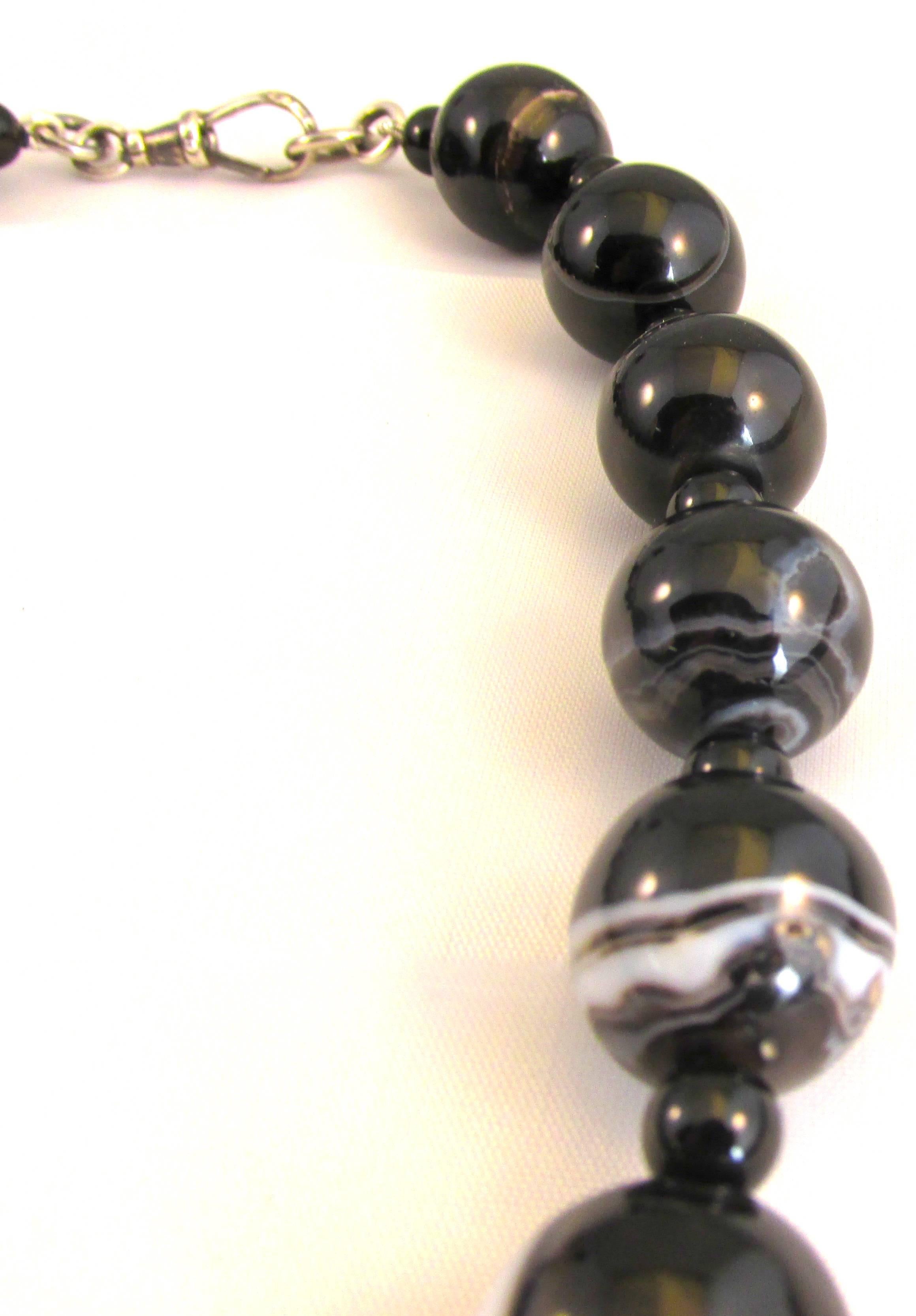 Bold Victorian banded agate bead necklace with a silver dog tag clasp. The 19 large banded agate beads are interspersed with small black agate beads. The necklace measures 17 1/2