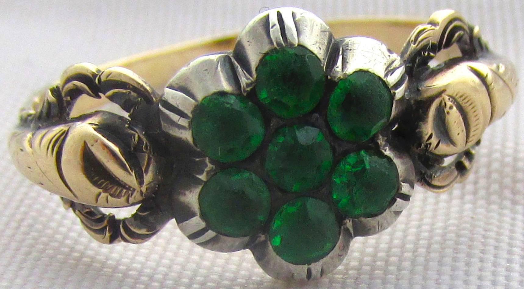 Charming Georgian green paste cluster ring in a silver floral motif setting with an elaborate 12K gold band. Lovely to wear day or night the ring dates to 1820, is a size 6 and measures 3/8" at its widest. 
