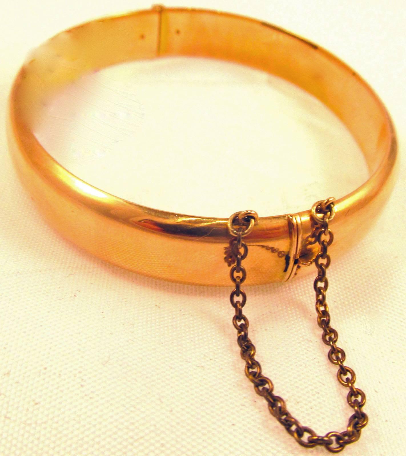 Lovely early 20th century gold bangle bracelet marked 15K and made in England c. 1920. The bracelet has a safety chain and measures 3/8