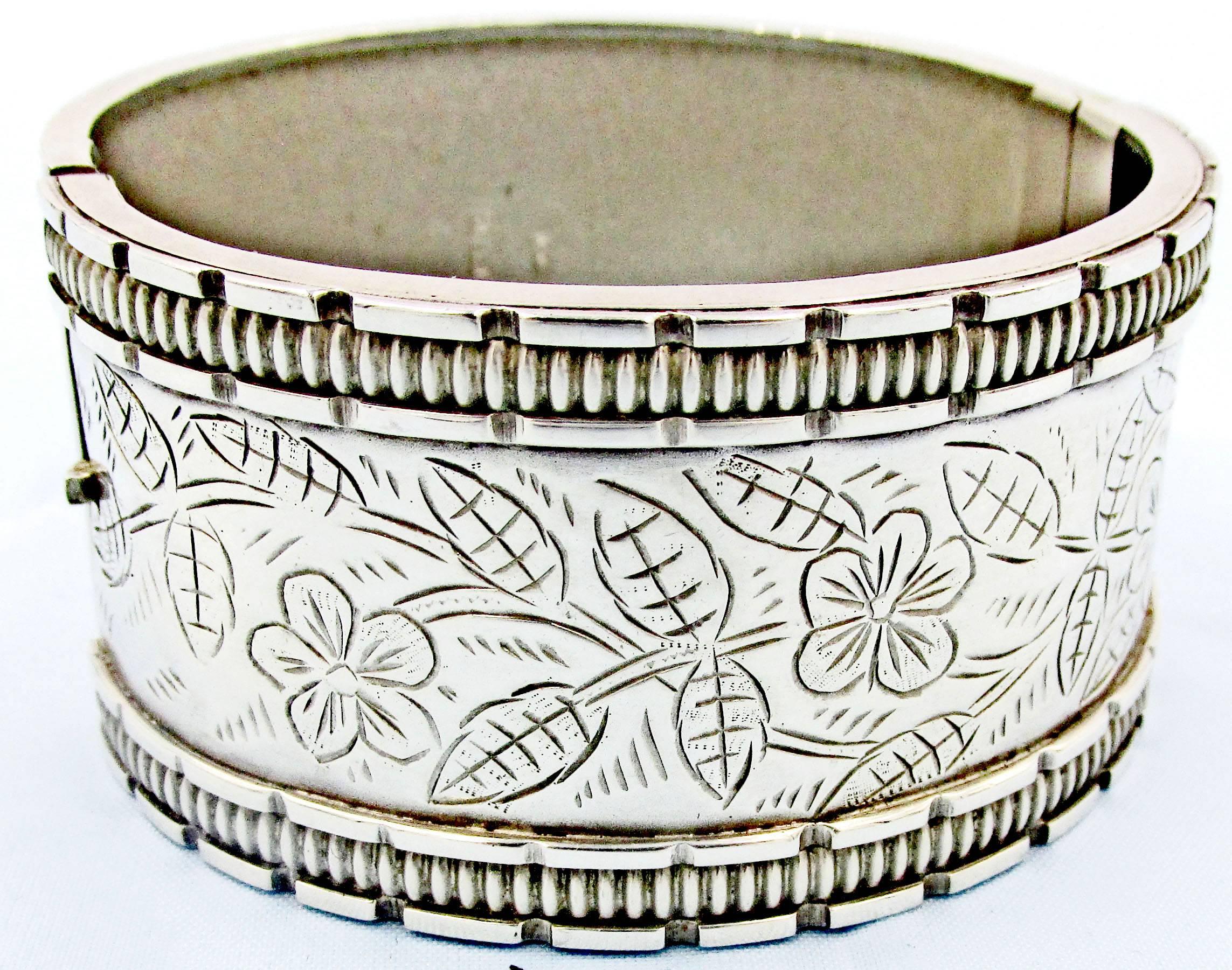 Victorian sterling silver cuff bracelet engraved with flowers and leaves under a ribbed border. The bracelet is stamped with the hallmarks for Birmingham 1883. Bangle bracelets were very popular during the Victorian era. 