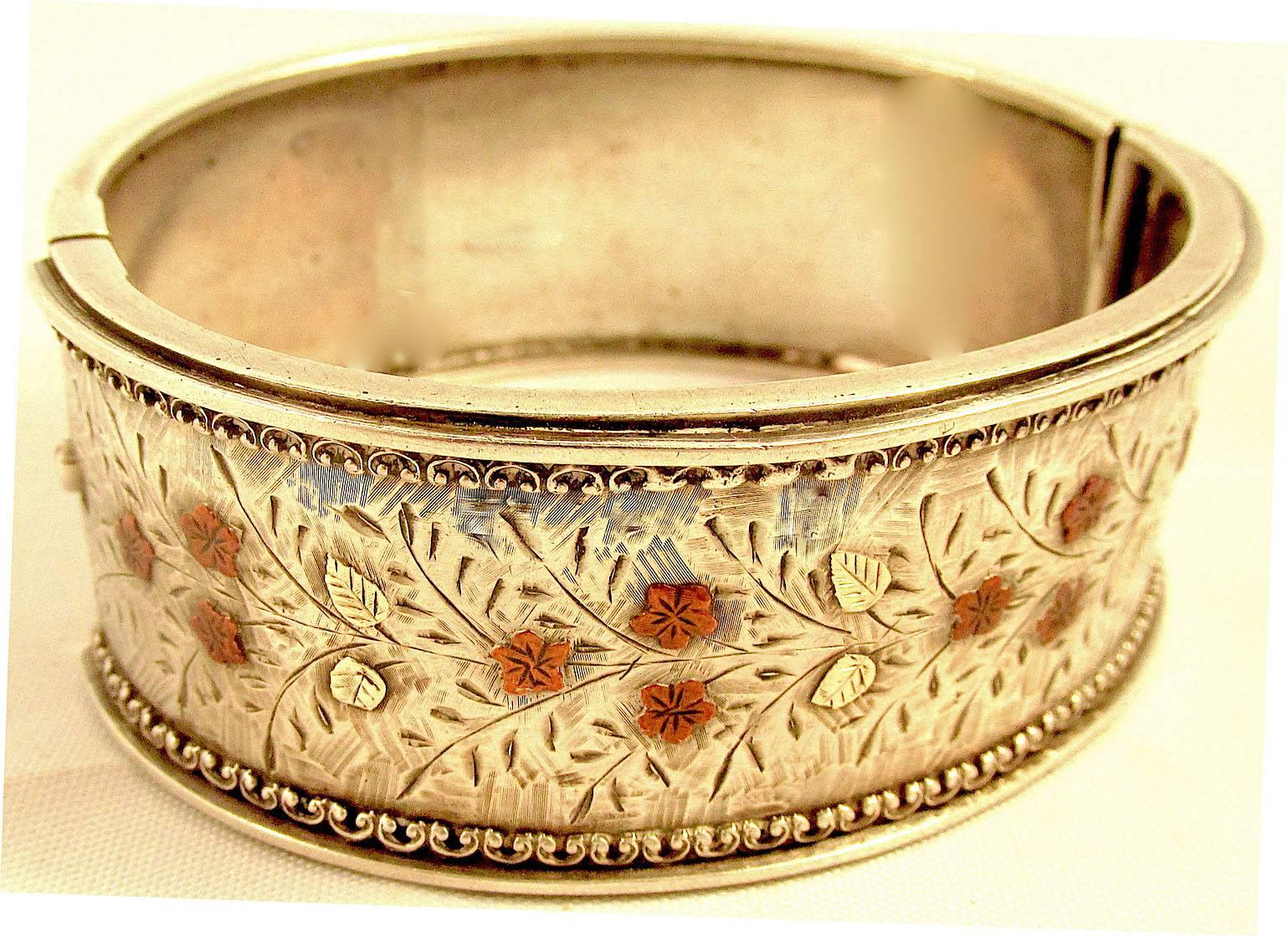Victorian silver cuff bracelet enhanced with rose gold flowers and yellow gold
leaves. Cuff bracelets were very popular in the Victorian era and this one special due to its added gold figures. The bracelet measures 1