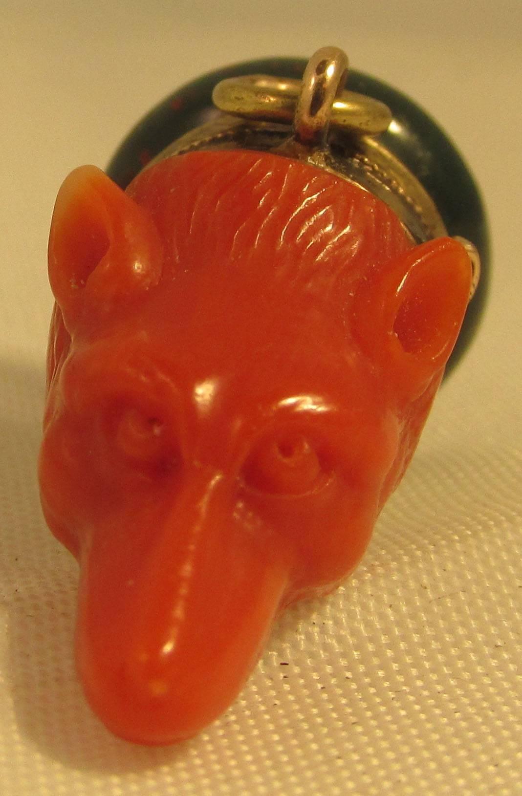 Unusual Victorian fox head fob carved of coral with an engraved collar of 15K gold and a base of bloodstone. This rare piece measures 1 1/8" long by 5/8" wide and 5/8" deep. Wonderful to wear on a chain or add to a bracelet of charms.