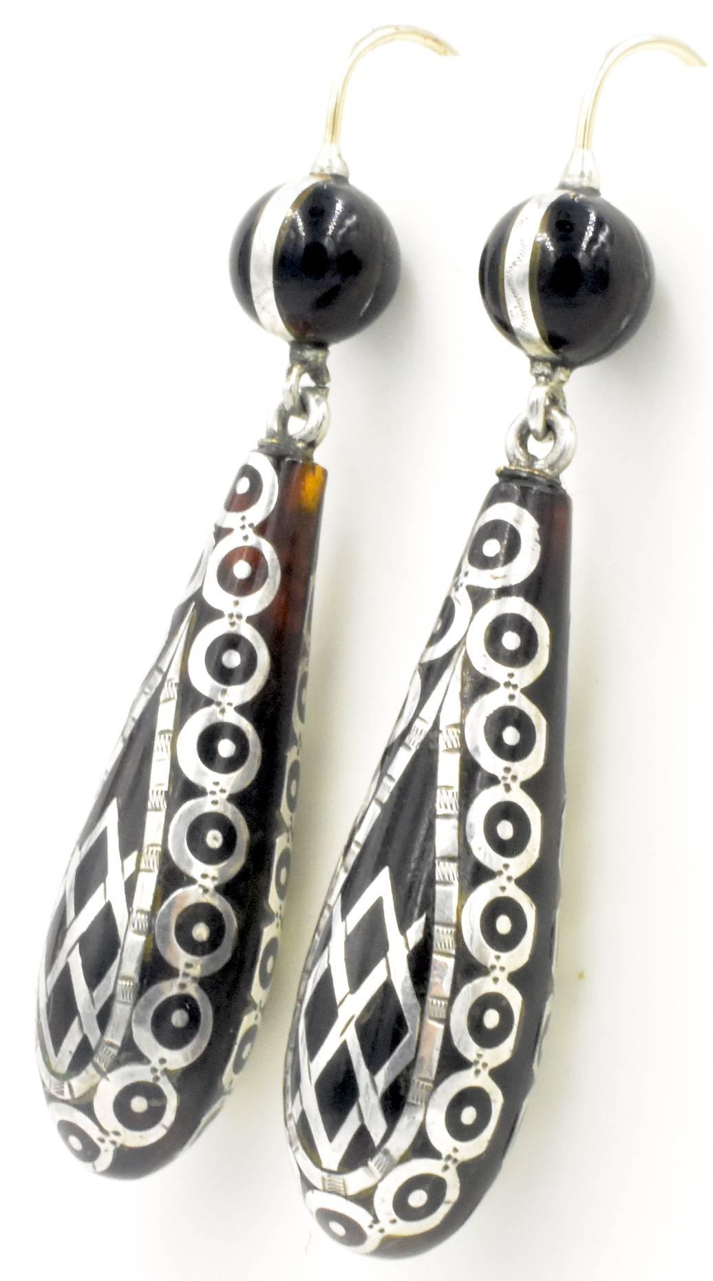 Striking Victorian earrings inlaid with silver in tortoiseshell. This work is called pique which was popular in the late 1800's not only for jewelry but for other items such as small purses and note books.The technique was brought to England by the