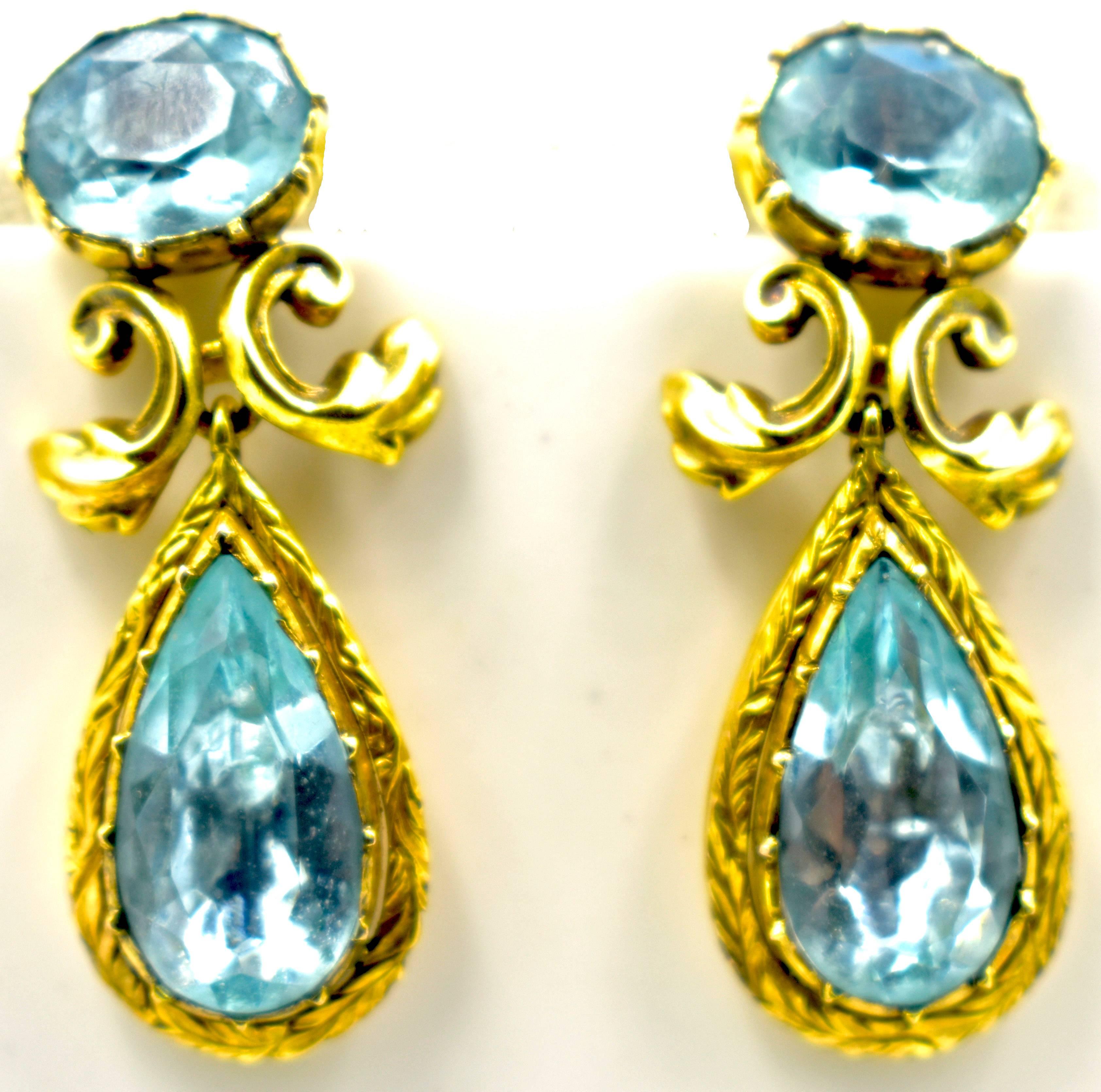 Sparkling Georgian aqua and 18K gold drop earrings. The earrings have a leaf motif on the center gold work and also engraved on the gold framing the drops.
The earrings measure 1 3/4" long and 5/8" at their widest.  Original backs have