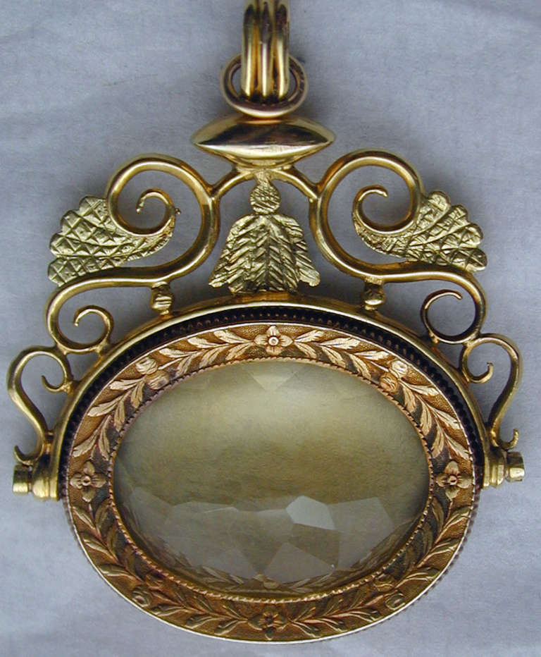 Magnificent early Victorian spinner fob in 18K two color gold, engraved with a foliate design and set with a large intricately faceted citrine. The citrine spins on an axle and can be worn with either side showing.  Wonderful to wear as a pendant on