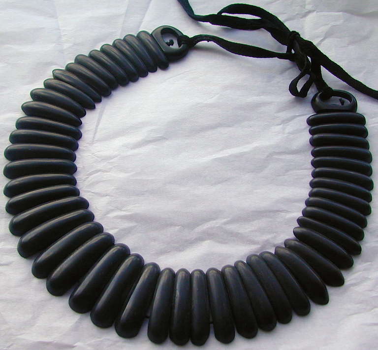 Smart and tailored gutta percha necklace or collar, tie it on and walk away. Gutta percha is a black or brown hard rubber like material made from the sap of a Malayan tree. In the late Victorian period it was molded in various forms to make jewelry.