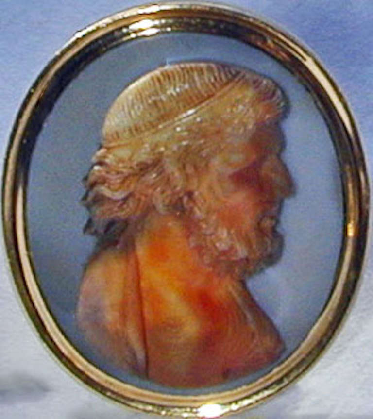 Exquisitely carved realistic portrait of a man in agate, set in an 18K gold ring mount of the period. The quality of the carving brings to life the person depicted. He is real, he lived. We see him now as he was, wavy hair, curly beard and furrowed