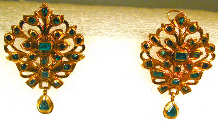 Sparkling 18th century Iberian emerald earrings set in 15K gold with a floral, foliate and bow design. The earrings measure 1 1/2