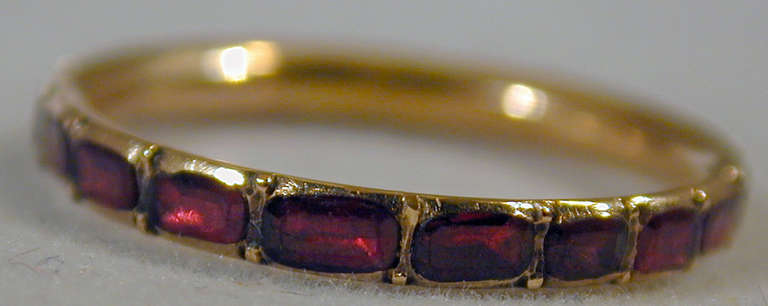 Georgian 15K gold and almandine or purplish-red garnet eternity band. Thin bands like this one are hard to find and highly prized. When worn with other rings, for example between two gold bands, they make a wonderful 