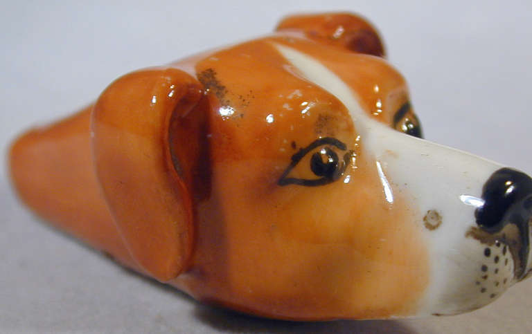 Porcelain hound head whistle made by Royal Worcester. This sweet faced dog may be worn as a pendant on a chain or just kept as a pet. The hound measures 1 3/8