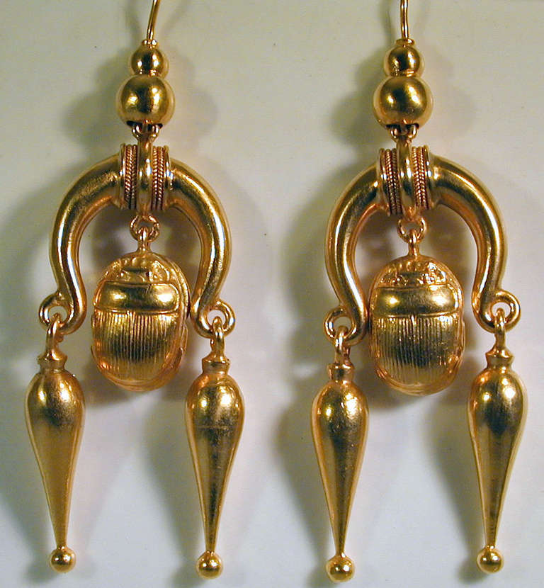 Victorian 15K earrings with a central scarab drop flanked by two pendeloque drops. Scarabs were regarded are sacred by the ancient Egyptians and used as a symbol of life and rebirth. With the rediscovery of Egyptian treasures in the 1900th century