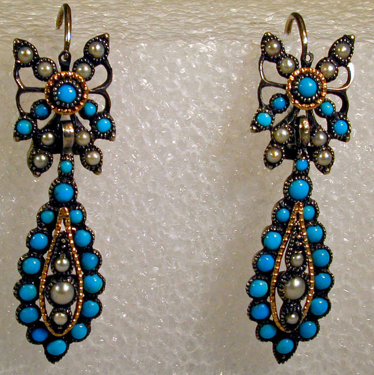 Victorian turquoise and pearl drop earrings set in silver and gold with butterfly motif tops. The gold embellishment is tiny cannetille beading. The earrings measure 1 7/8