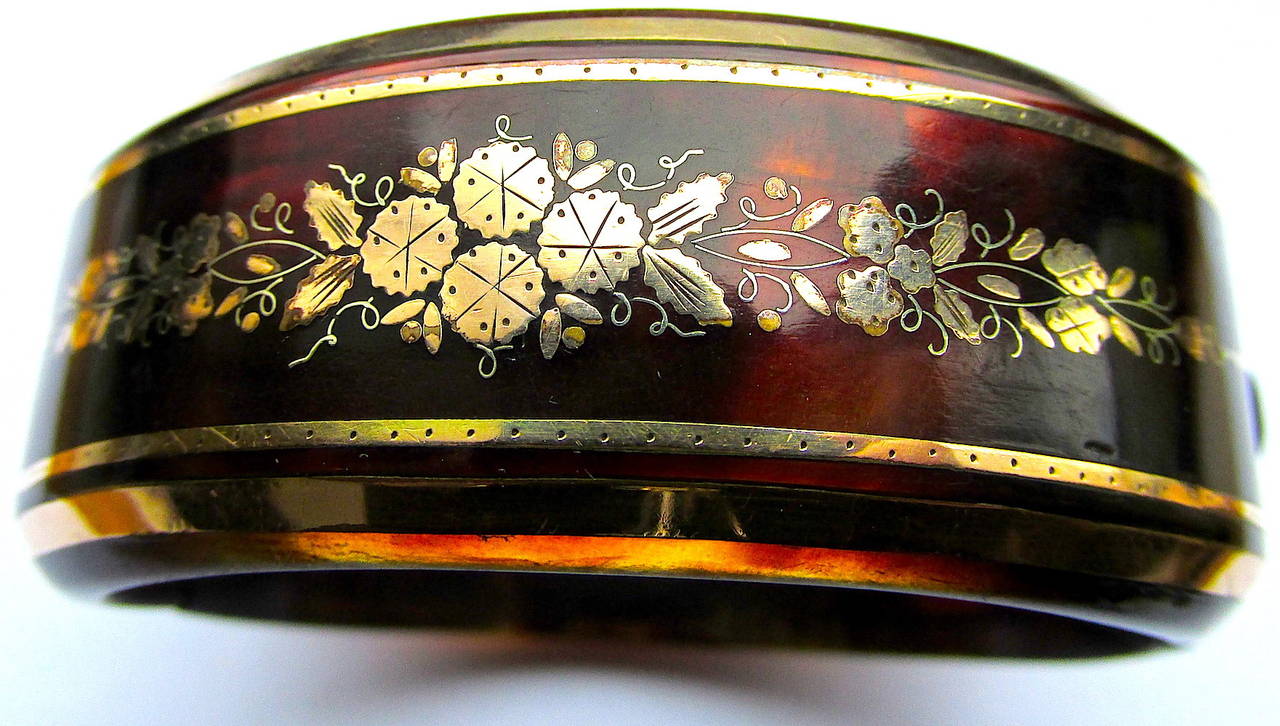 Lovely Victorian floral motif pique hinged bangle bracelet. Pique is tortoise shell inlaid with gold and silver. It was brought to England by the Huguenots at the end of the 17th century. It reached the height of its popularity in the 1870s and