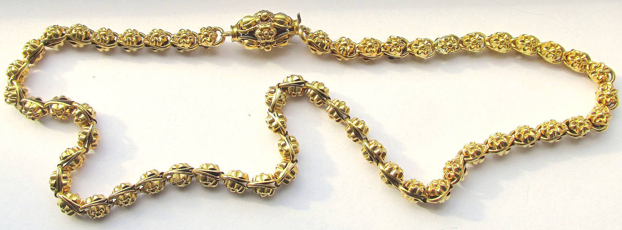 Elaborate Early Victorian 15K gold necklace embossed with floral decor and having its original clasp, which would have been worn at the front of one's neck as pictured in the photograph. A lovely way to show all of its intricate and beautiful