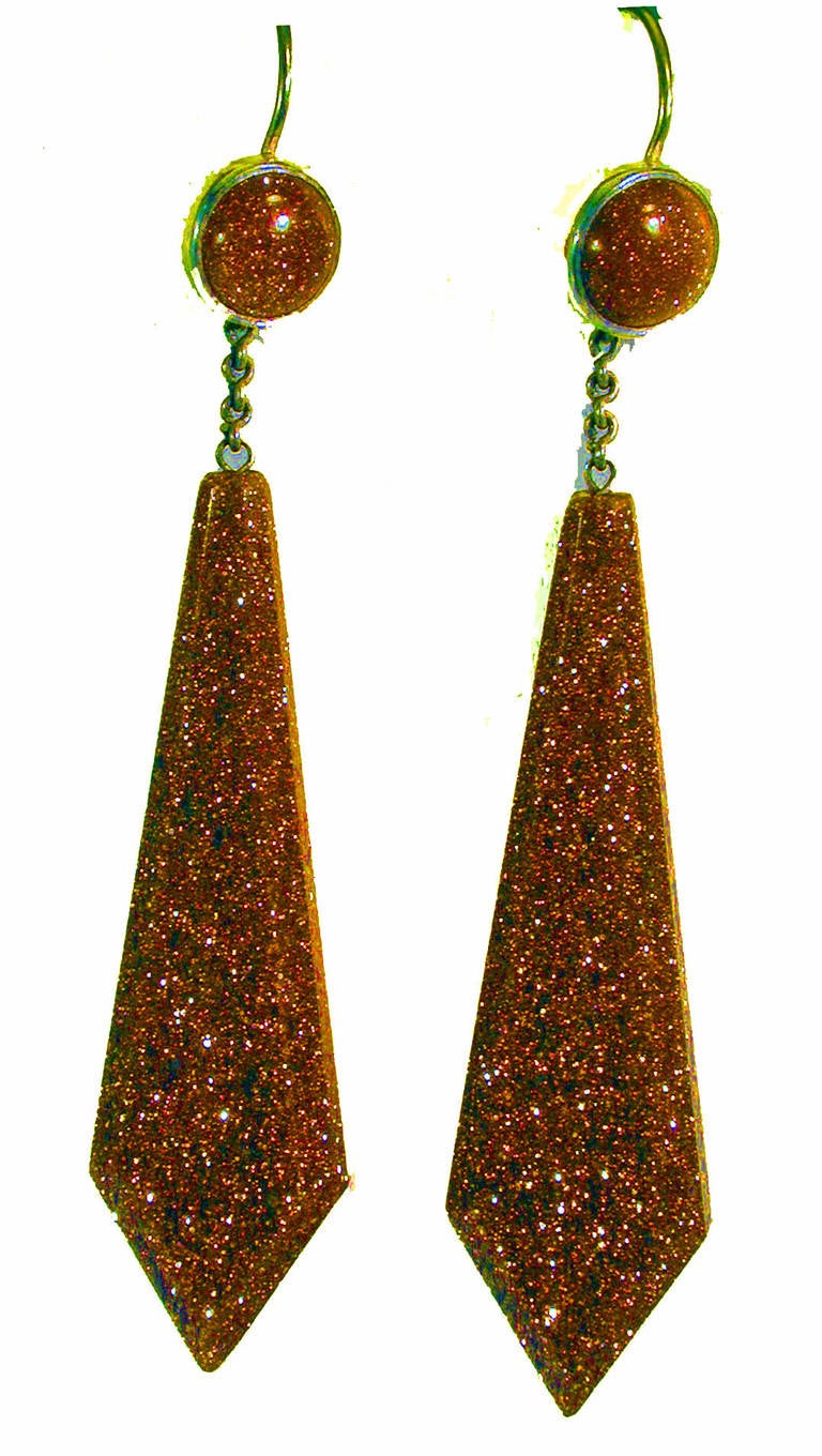 Dramatic goldstone long drop earrings set in silver will make a wonderful addition to any collection of period jewelry. Goldstone was invented in the 17th century in Italy. It is also called aventurine glass. The earrings measure 3