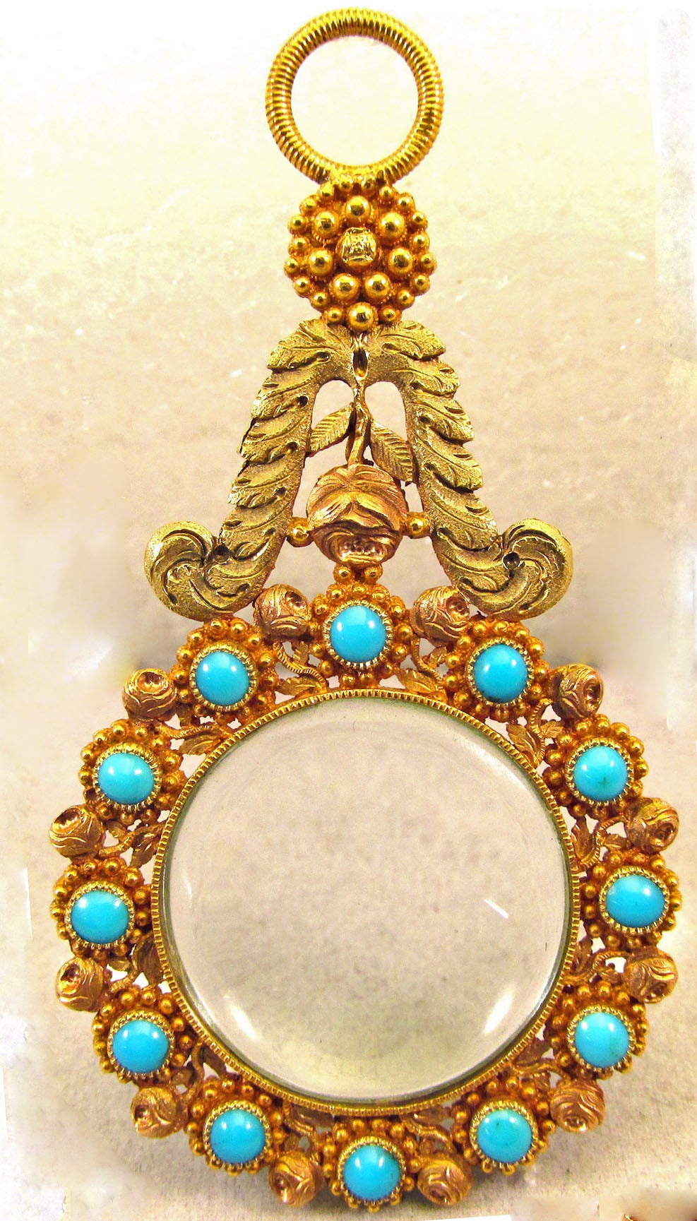 Unique Georgian quizzing glass or quizzer in three color 18K gold set with turquoise in a floral and leaf motif. The elaborate cannetille gold work is known for its intricate beads and coils and filigree. It became fashionable in England beginning