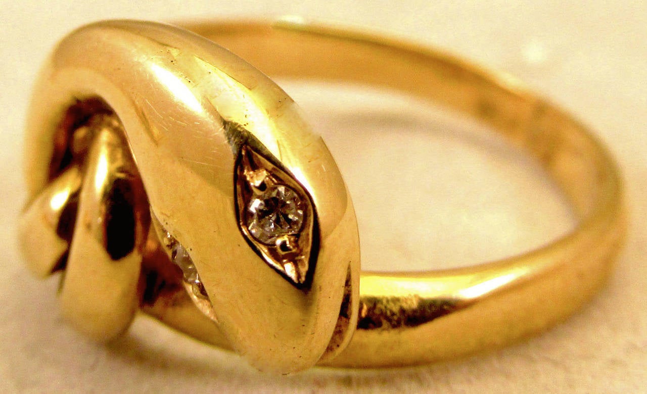 Swirling Victorian 18K gold snake ring with diamond eyes. The tail wraps itself  around the ring and tucks itself under the snakes head. Snake rings became popular in England when Queen Victoria received one as an engagement ring pfrom Prince