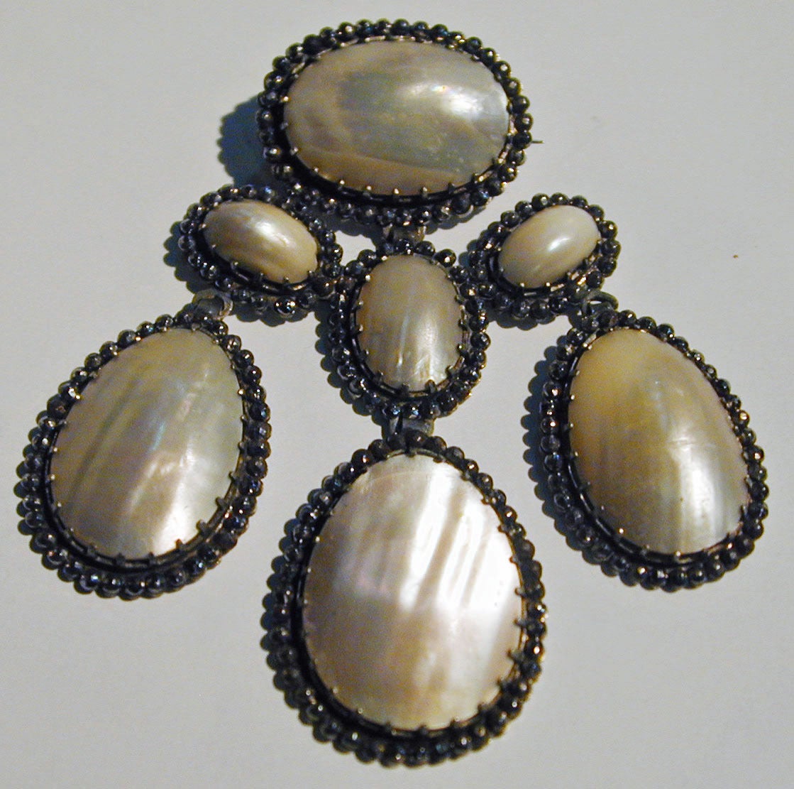 Magnificent Georgian brooch of coque de perles surrounded by iron pyrites. Coque de perle comes from the oval section of the pearly mollusk, the nautillus, found in the East Indies. This large brooch measures 3