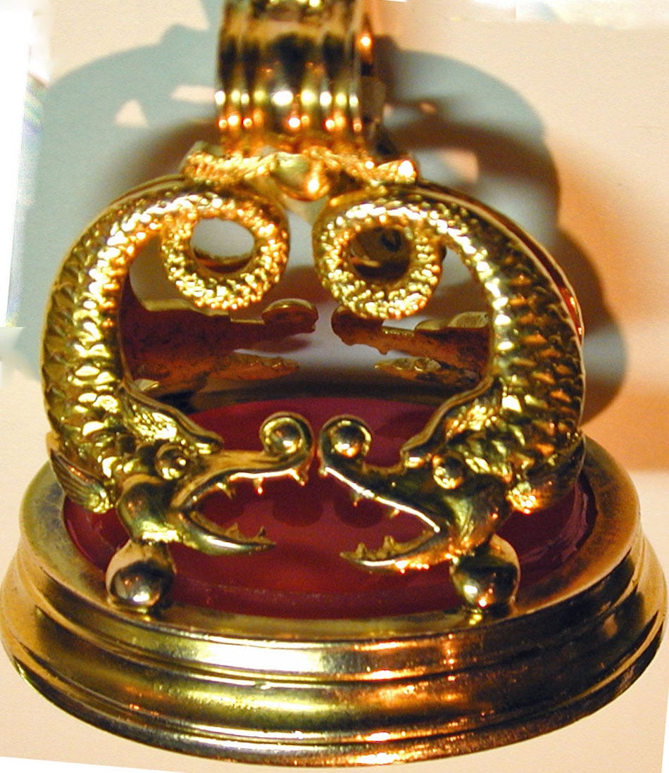 Bold Victorian 18K gold fob with four dolphins set with a carnelian intaglio of a coat of arms. Great to wear on a long chain or bracelet. This large, impressive piece measures 1 1/2