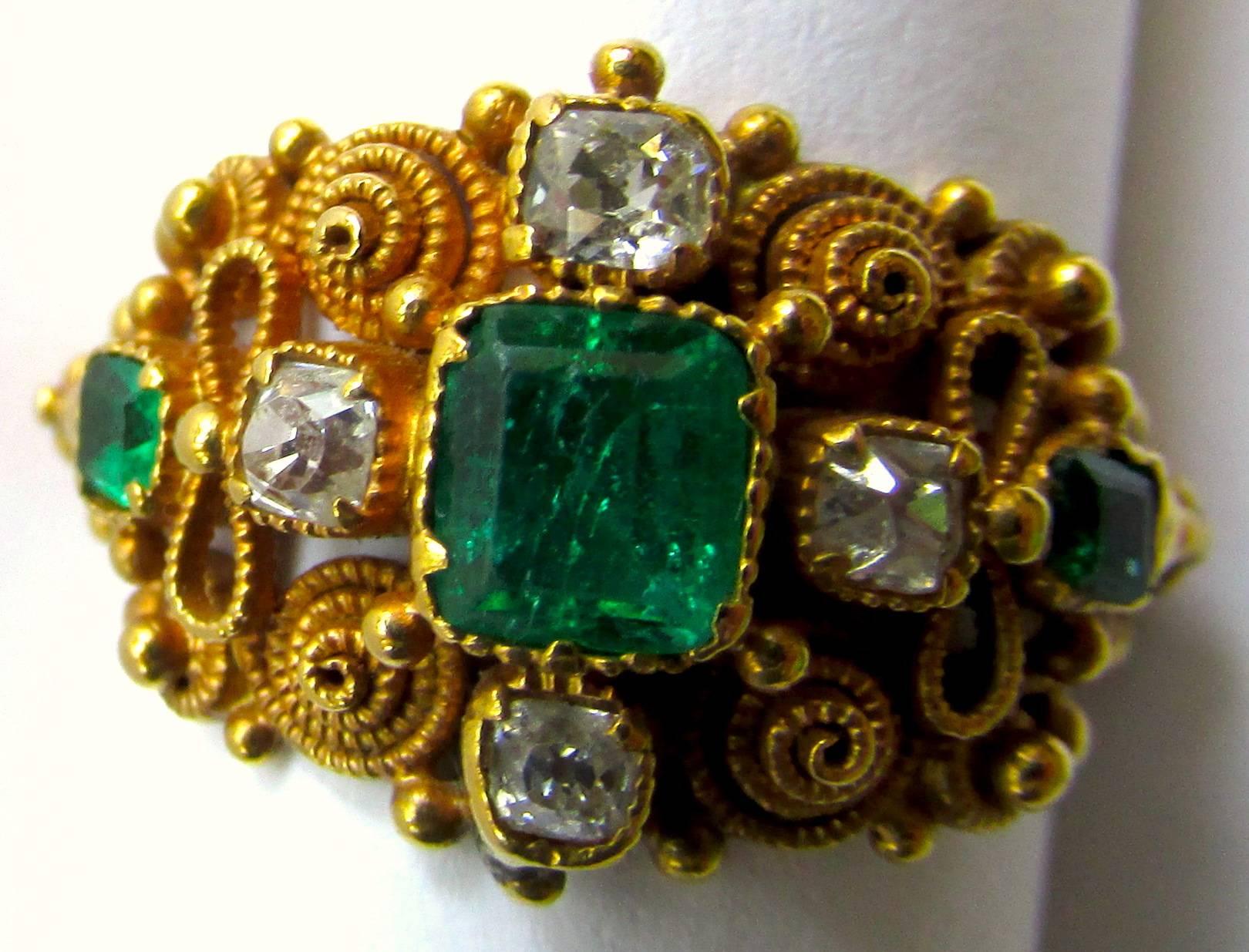 Georgian emerald and diamond ring in 15K yellow gold is exquisitely fashioned in cannetille work of twisted gold wire and tiny rosettes to resemble the gold lace of that period. The attention to detail is amazing, notice the elaborate band. The ring