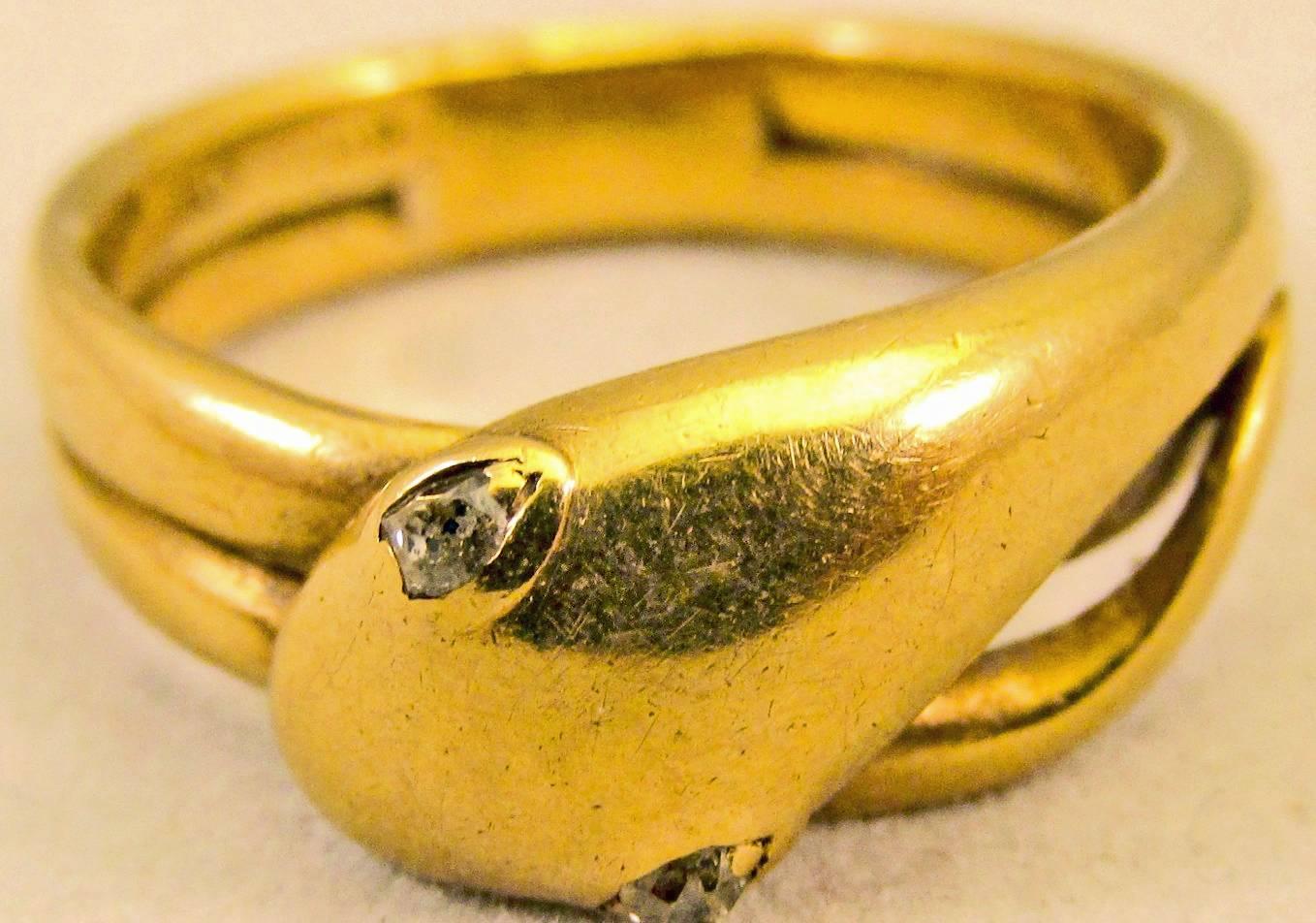 Striking Victorian snake ring marked 18K and set with diamond eyes. This bold snake has a twisted tail that circles twice around the finger.  The ring is a size 10.